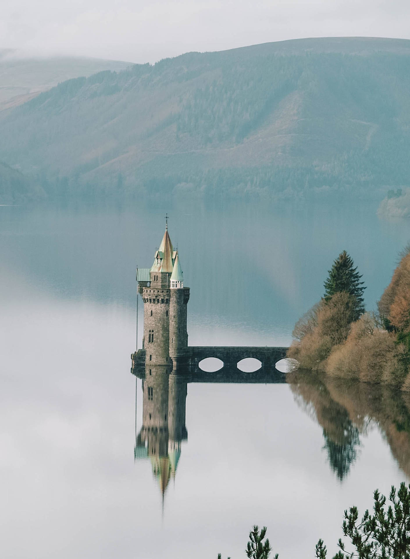 a castle sits on top of a lake Wallpaper