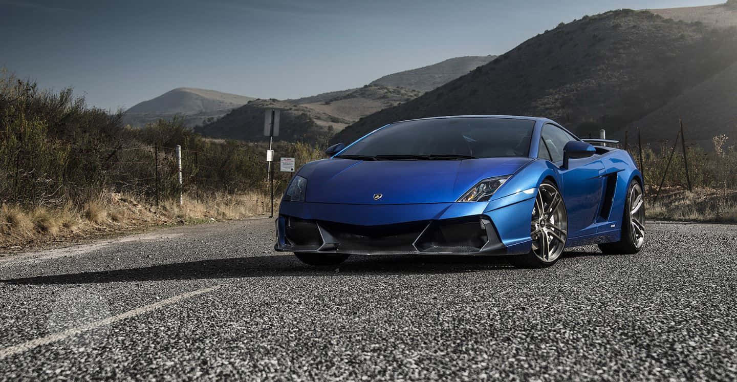 Sleek Lamborghini Gallardo cruising down the highway Wallpaper