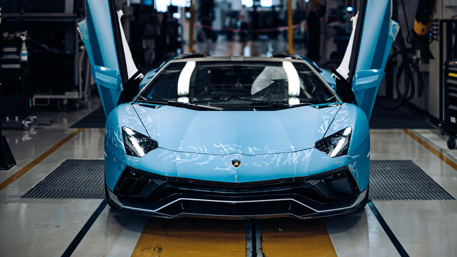 Et blå Lamborghini sportsvogn sidder i en fabrik