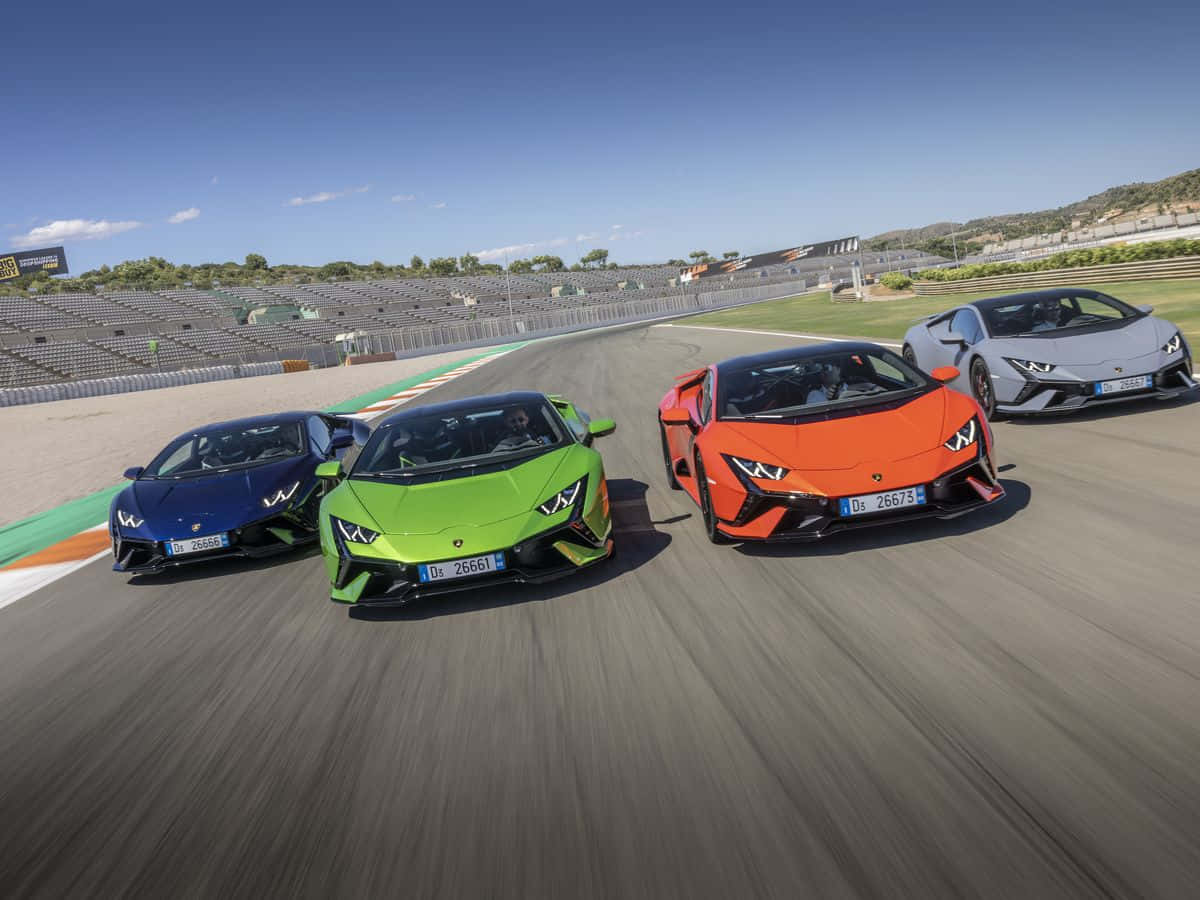 four lamborghinis are driving on a track