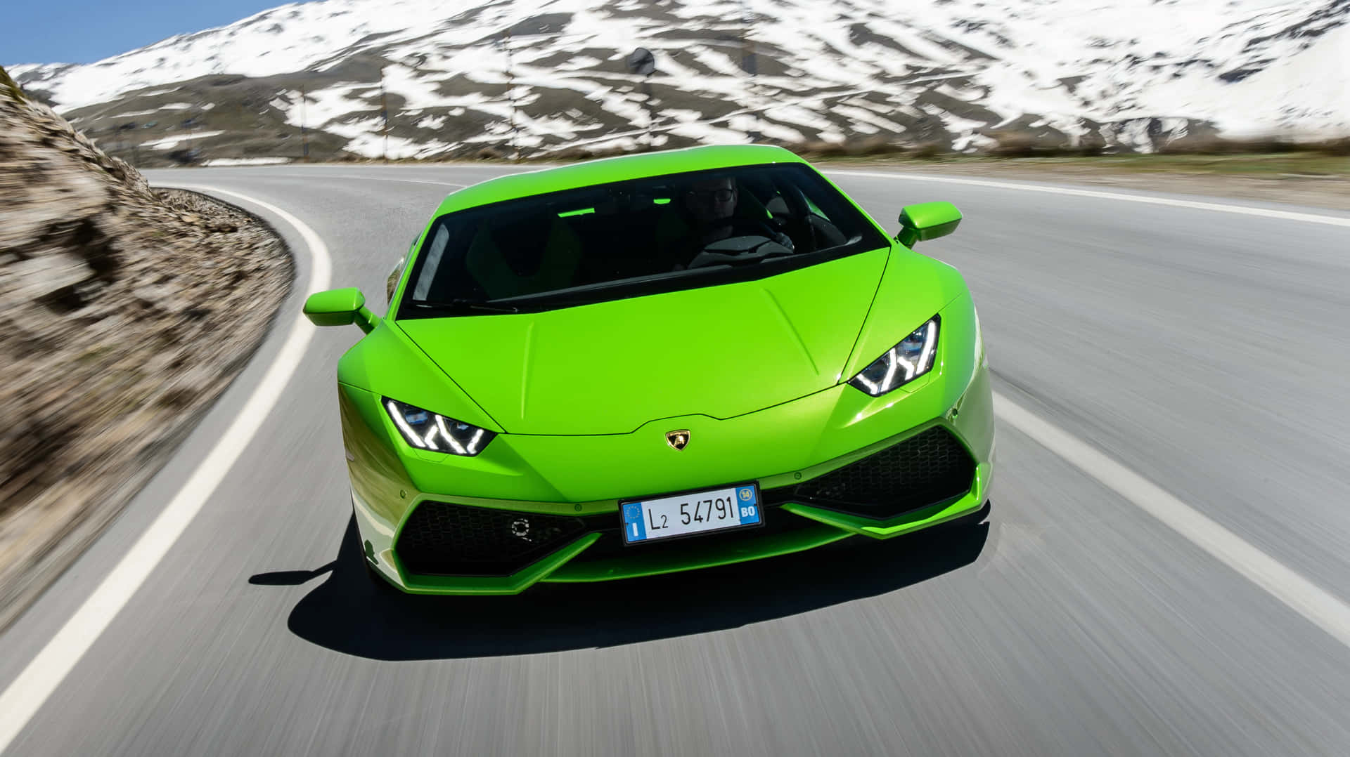 Lamborghinihuracán - Um Carro Esportivo Verde Dirigindo Por Uma Estrada De Montanha.
