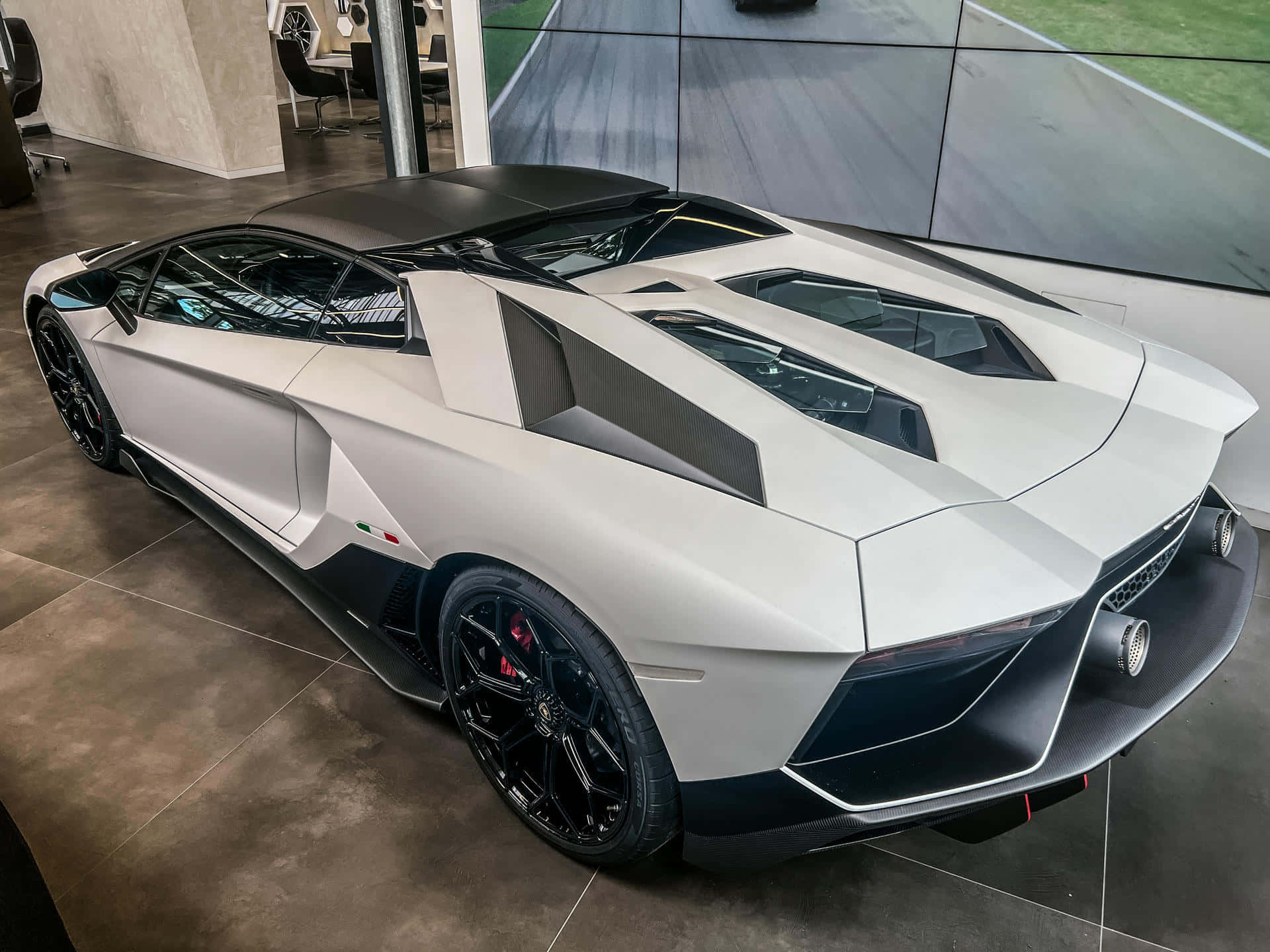 En hvid og sort Lamborghini Huracan parkeres i et showroom.