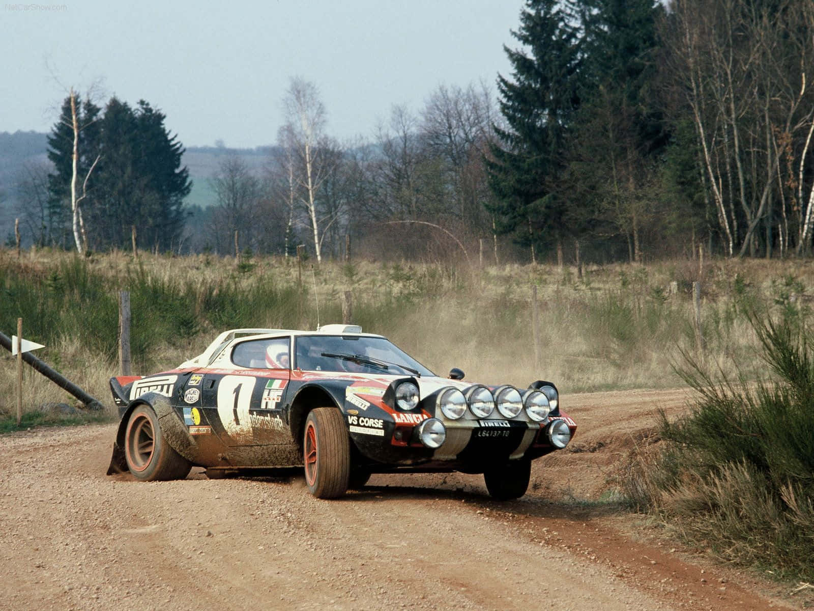 Caption: Classic Lancia Driving on Open Road Wallpaper