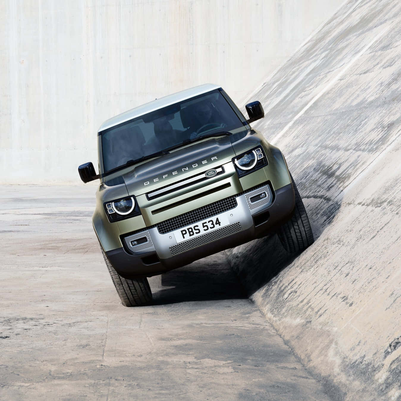 Rugged and Capable Land Rover Defender on the Move Wallpaper