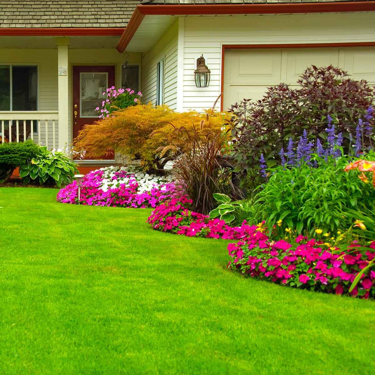 A House With A Lawn And Flowers In The Front Yard