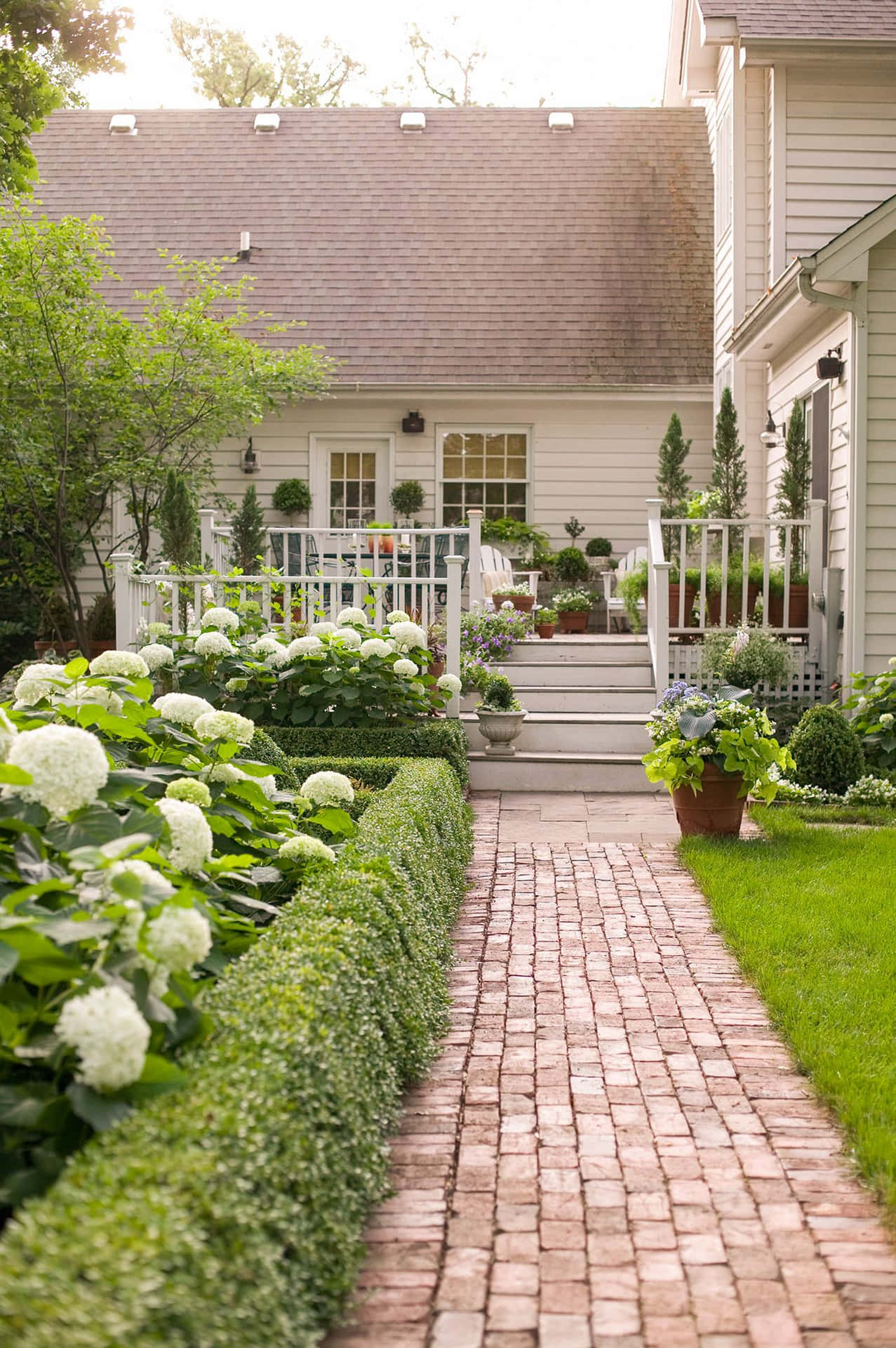 A Brick Walkway Leading To A House With A Garden