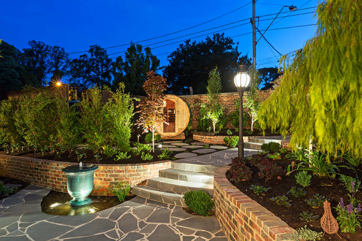 A Garden With A Fountain And Lighting