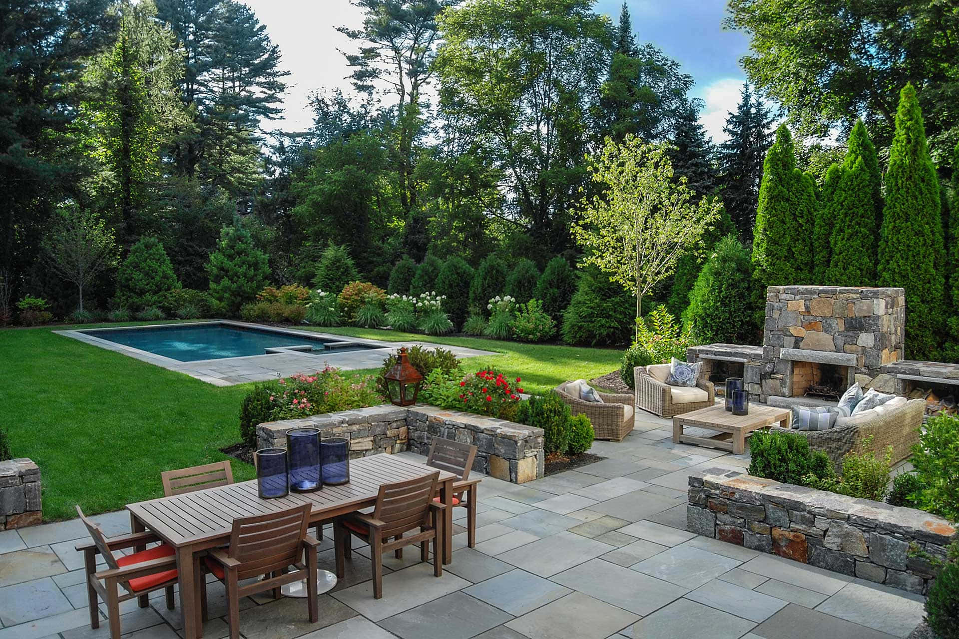 A Backyard With A Pool And Stone Patio