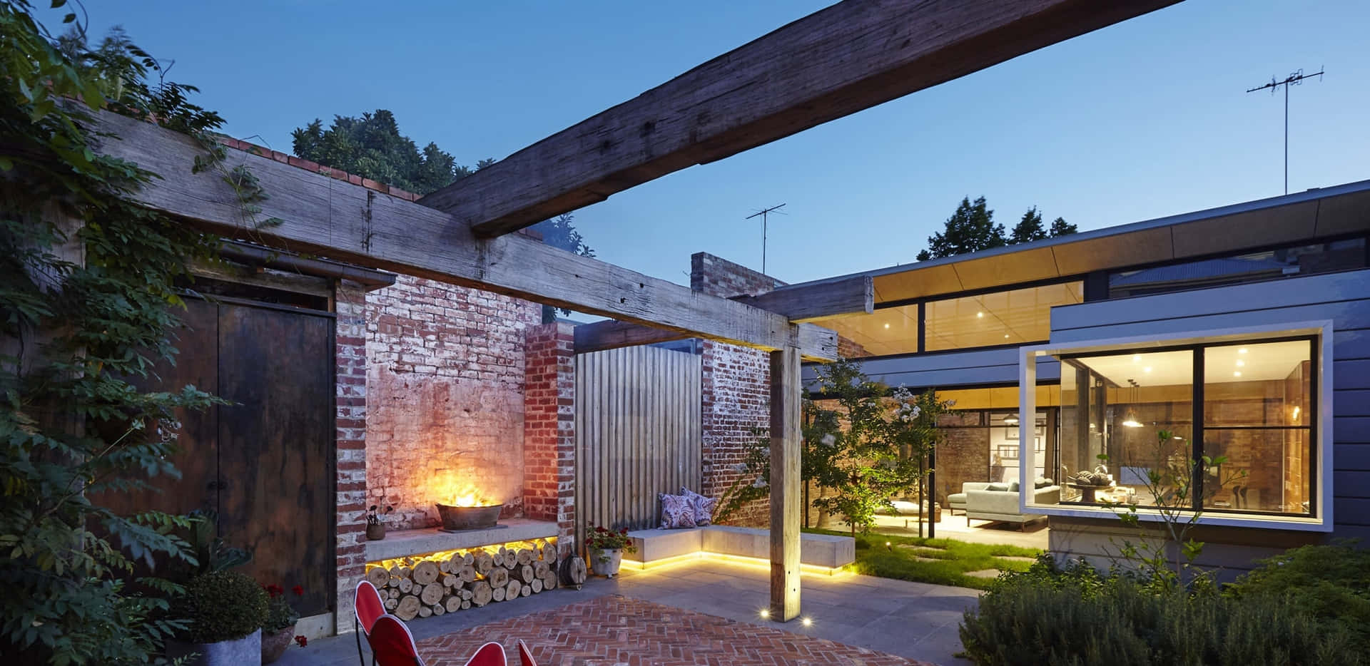 A Modern Backyard With A Brick Fireplace And A Brick Wall