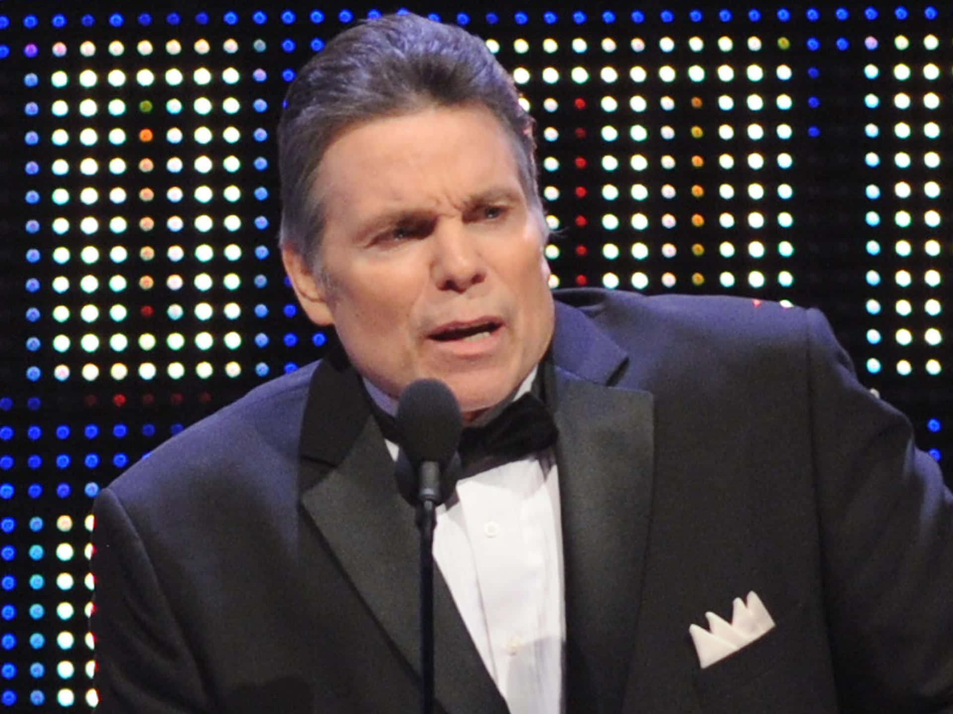 Lanny Poffo Holds A Microphone During An Interview Wallpaper