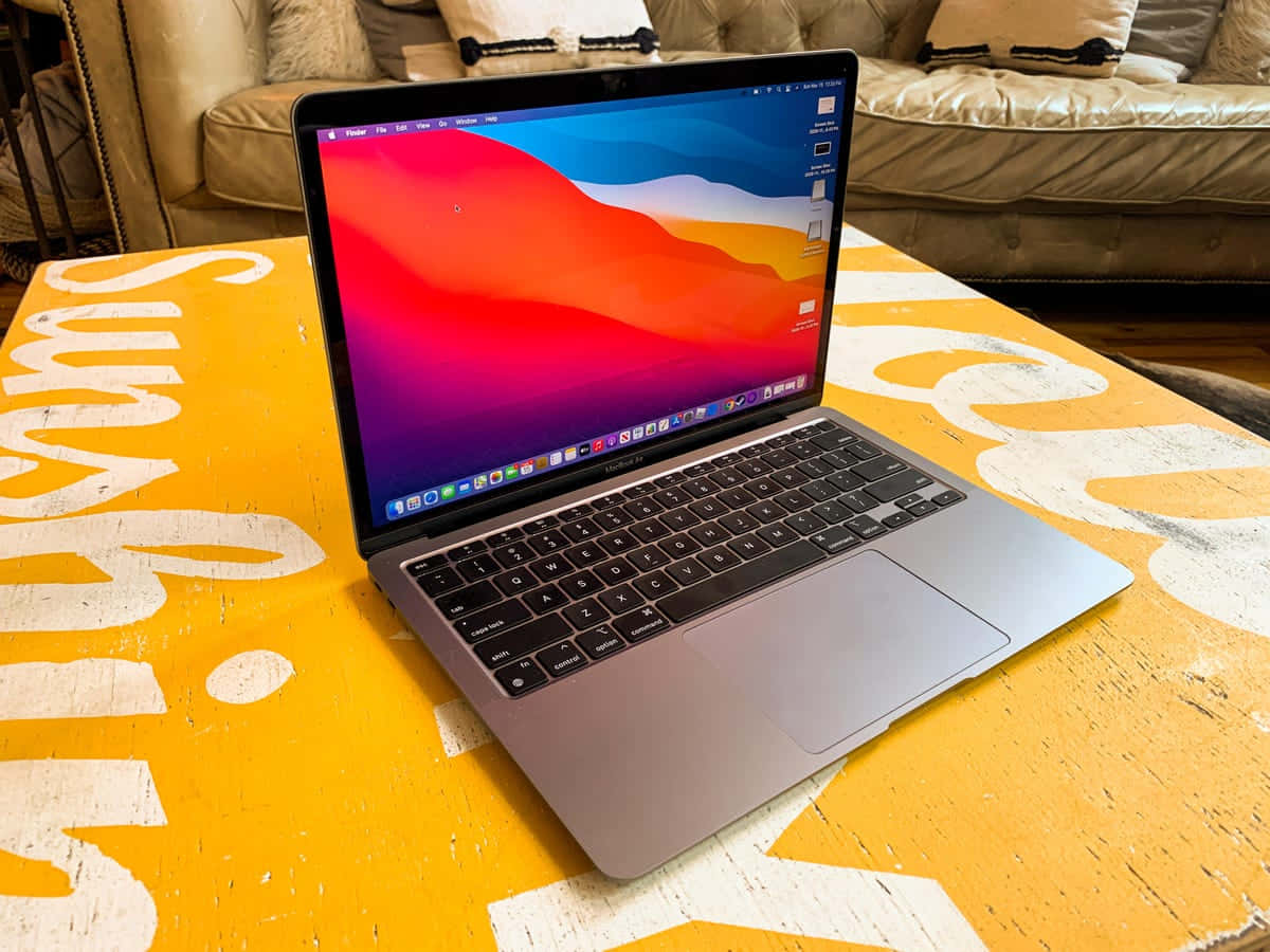 A sleek, modern laptop on a vibrant purple and pink background