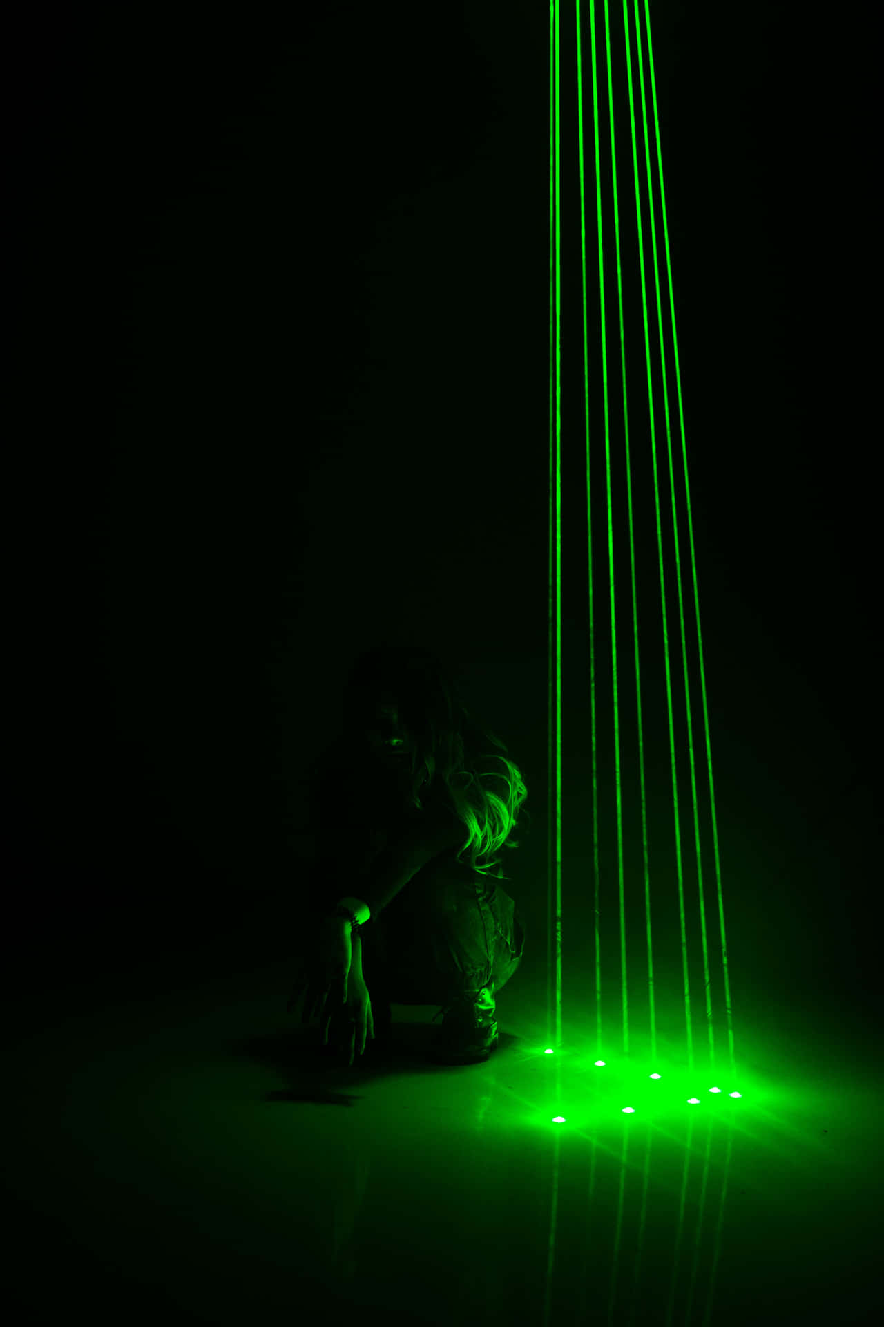 A Person Is Sitting In Front Of A Green Laser Light