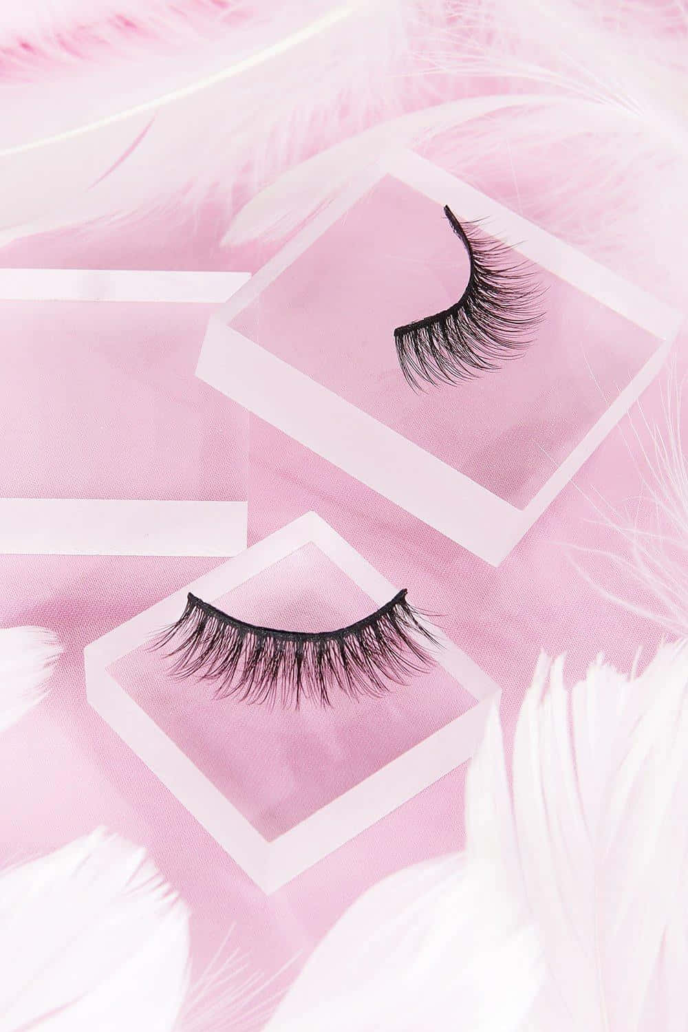 A Pair Of False Eyelashes On A Pink Background