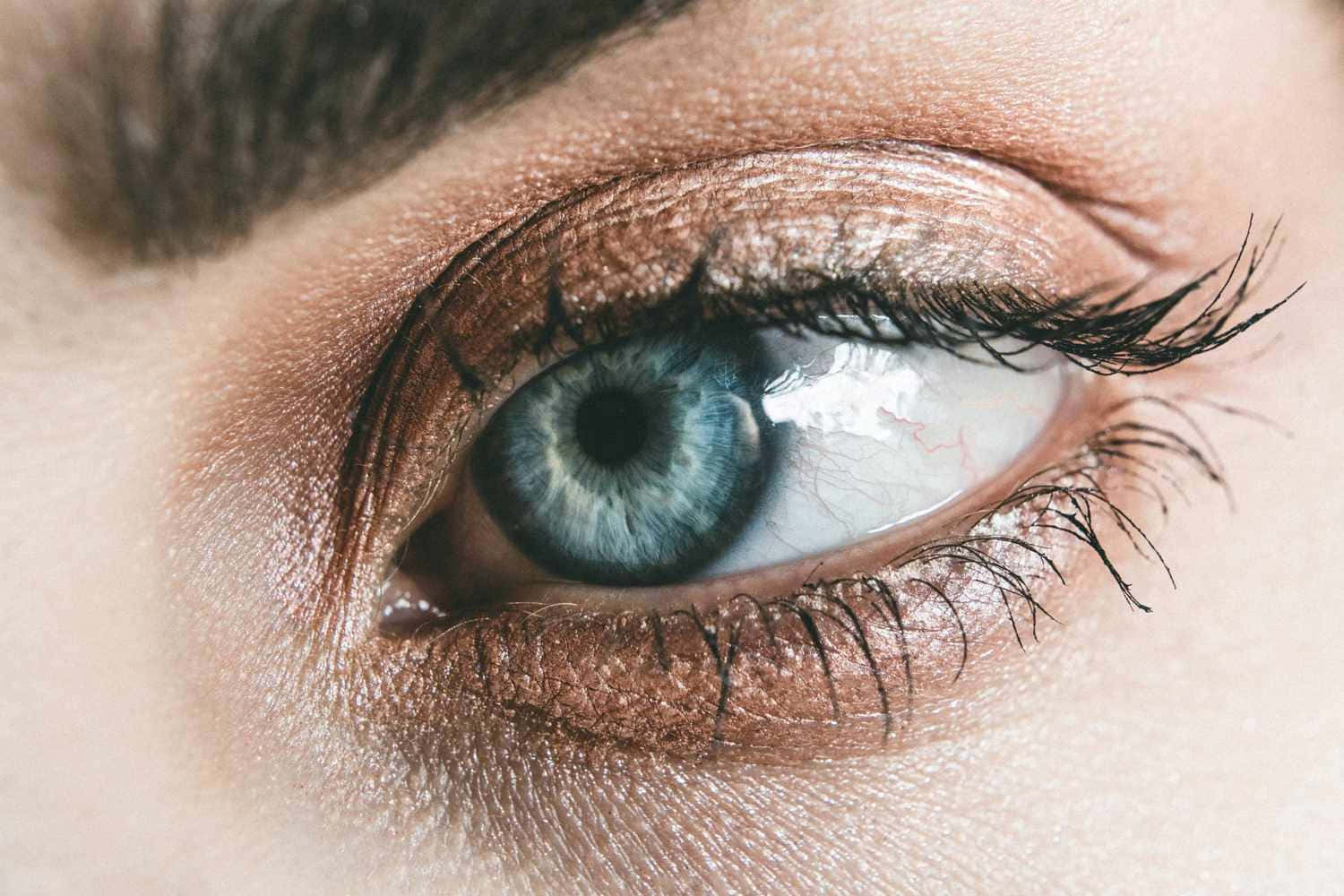 A Close Up Of A Woman's Eye With Blue Eyes