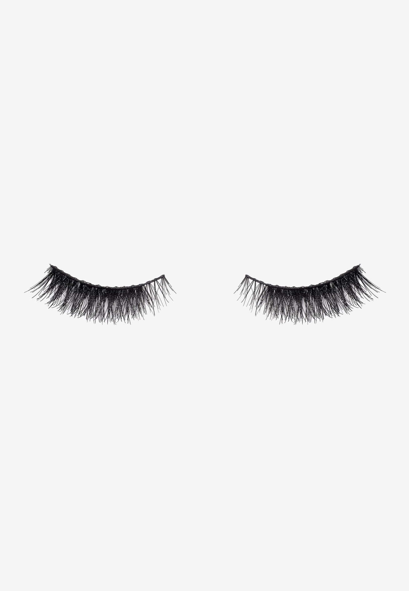 A Pair Of Black Eyelashes On A White Background