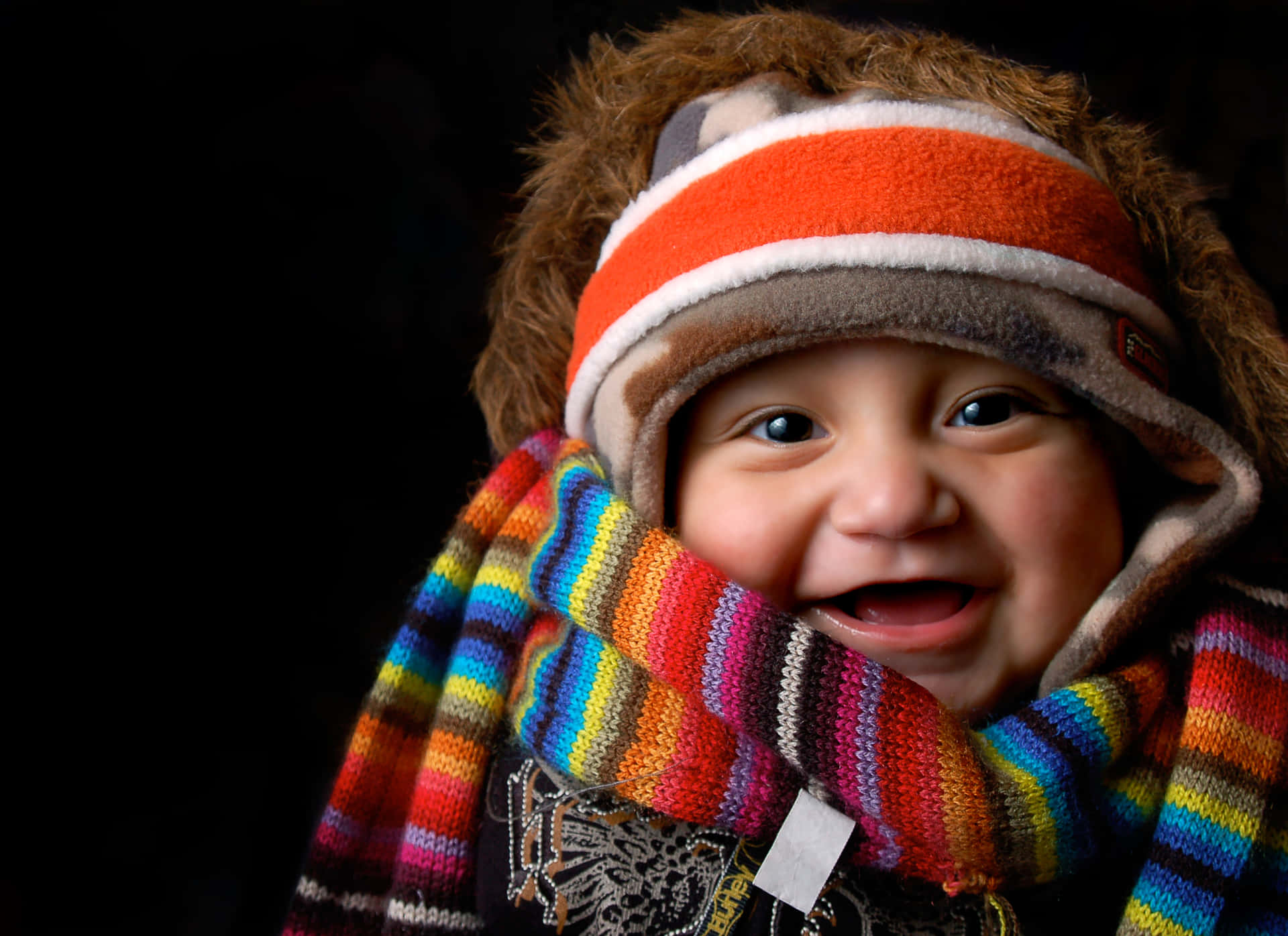 A Child Wearing A Hat And Scarf