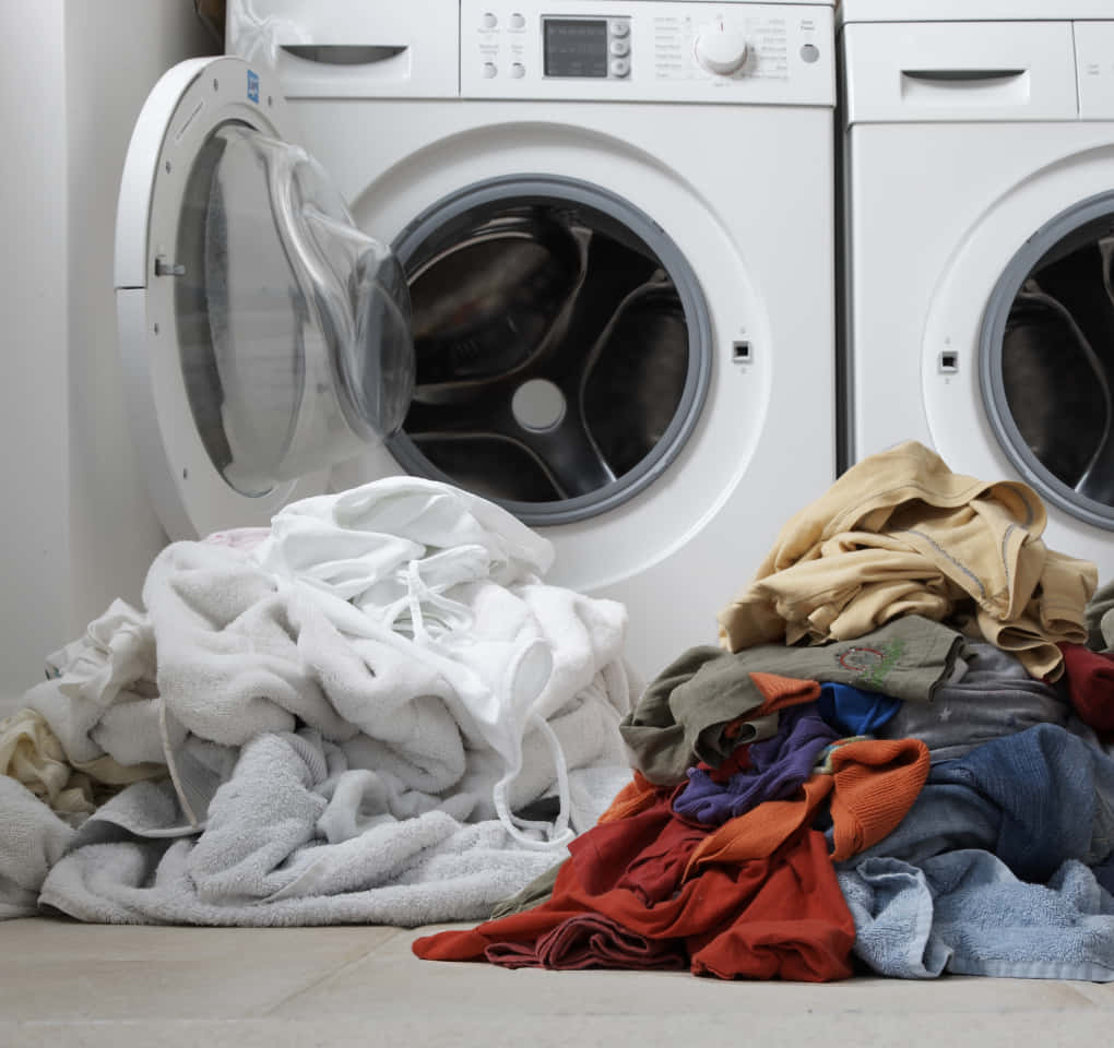 A Pile Of Clothes In Front Of A Washing Machine