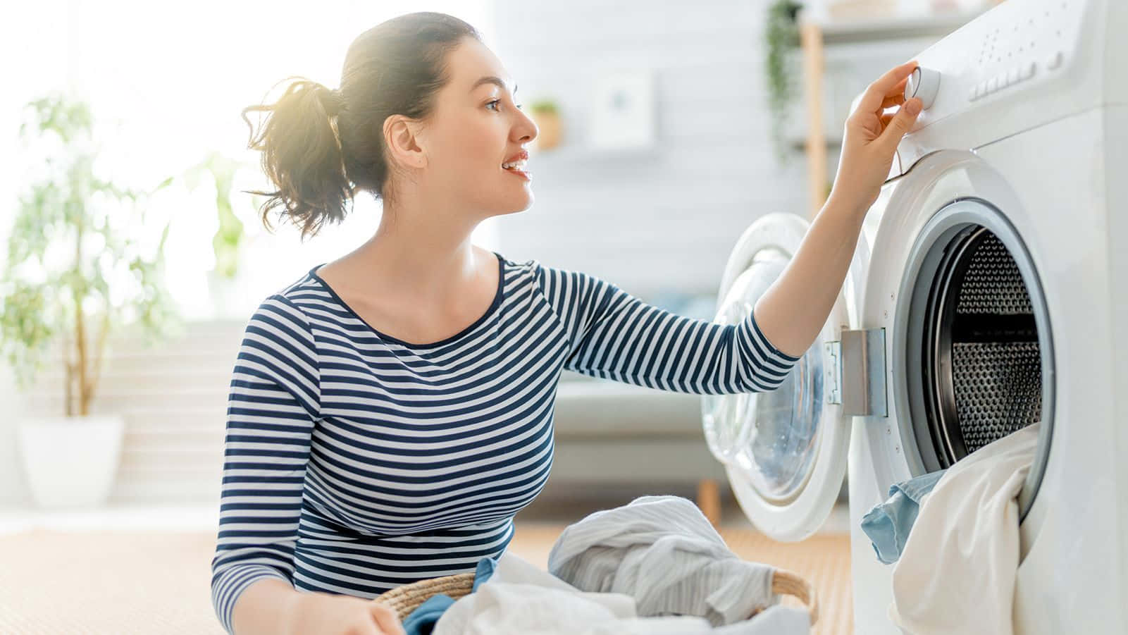 Kvinnalägger Kläder I Tvättmaskinen