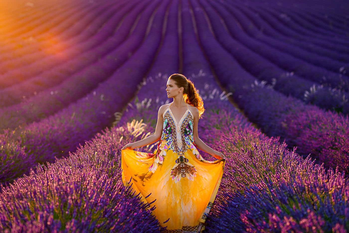 A Woman In A Yellow Dress Standing In A Lavender Field