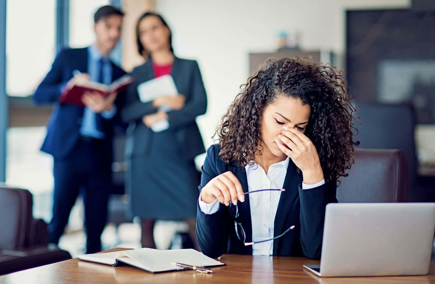 A Woman In A Business Suit Is Crying In Front Of A Group Of People Wallpaper