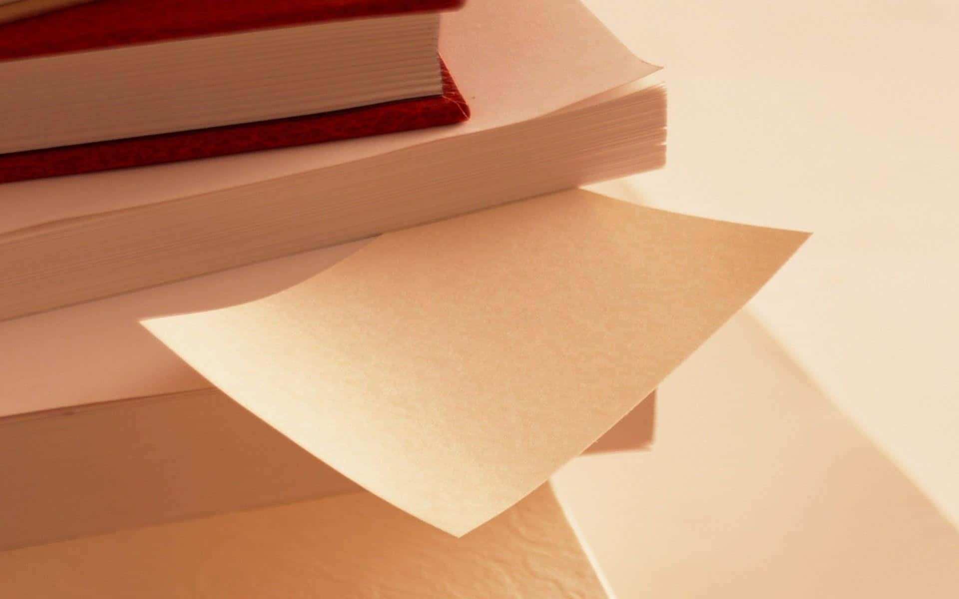 A White Paper Note Is On Top Of A Stack Of Books