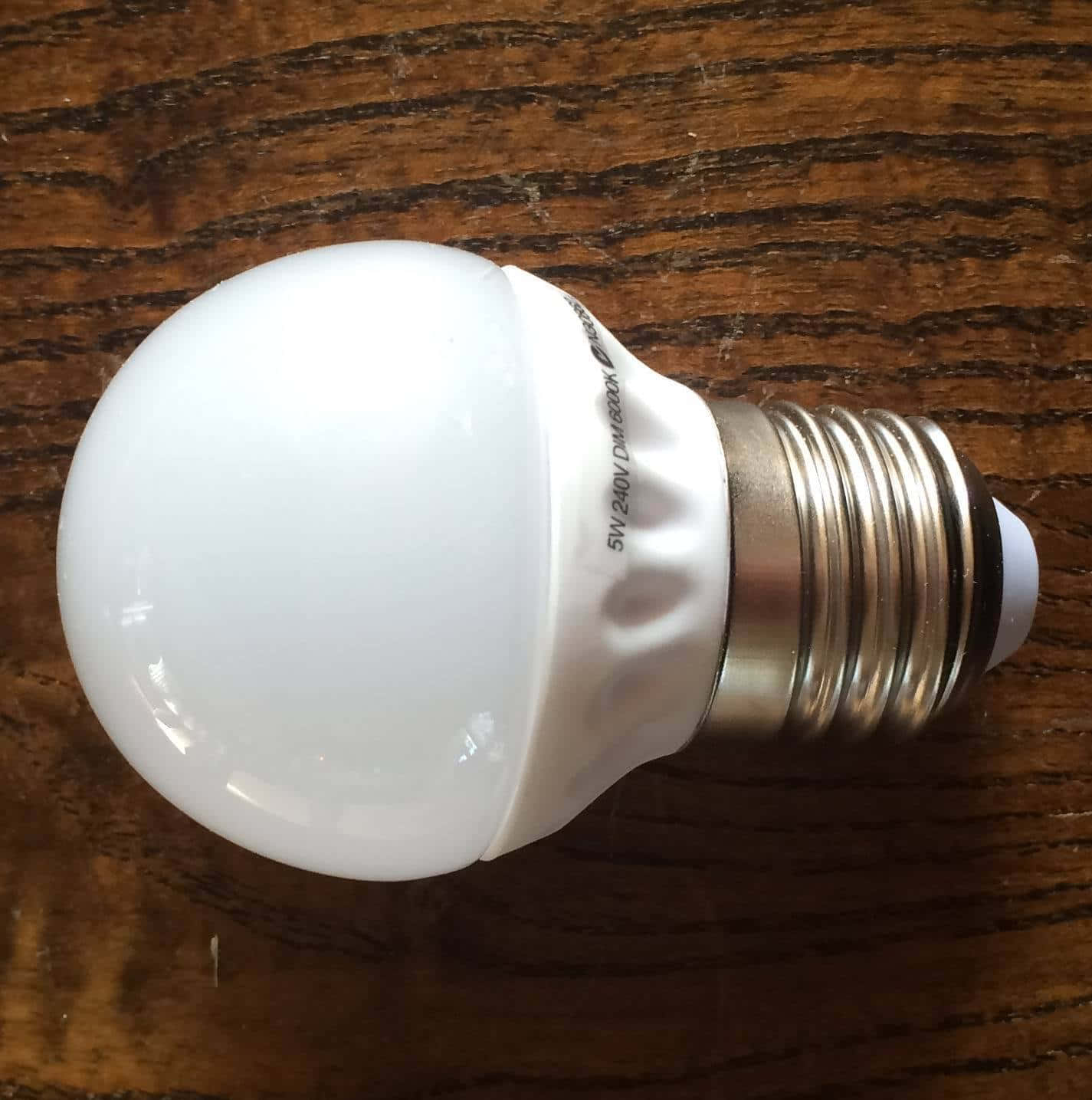 A White Light Bulb On A Wooden Table