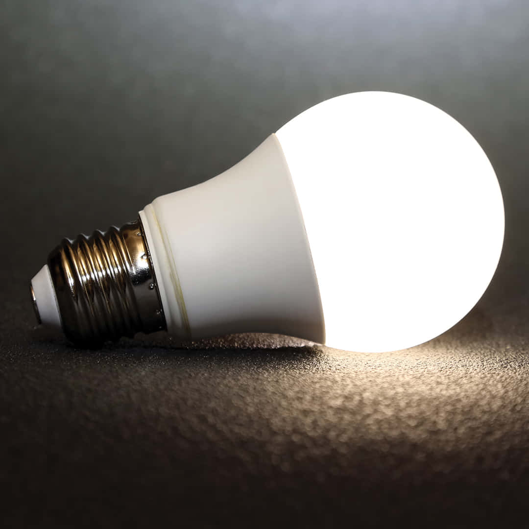 A White Light Bulb Is Shown On A Dark Surface