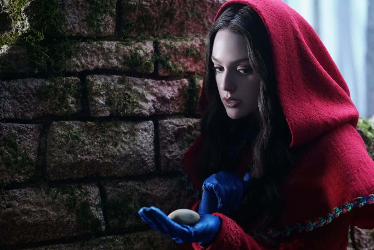 A Woman In A Red Hooded Coat Holding An Egg Wallpaper