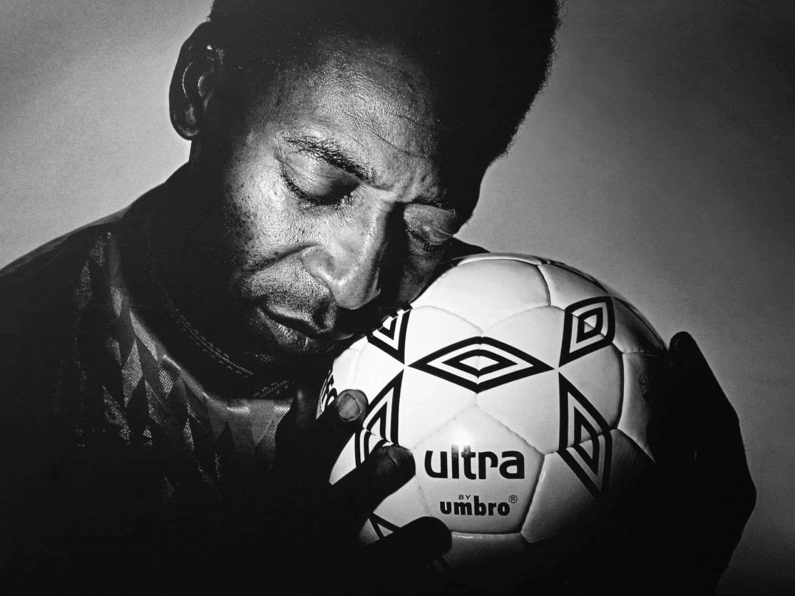 Legendary Footballer Lovingly Holding Soccer Ball Wallpaper