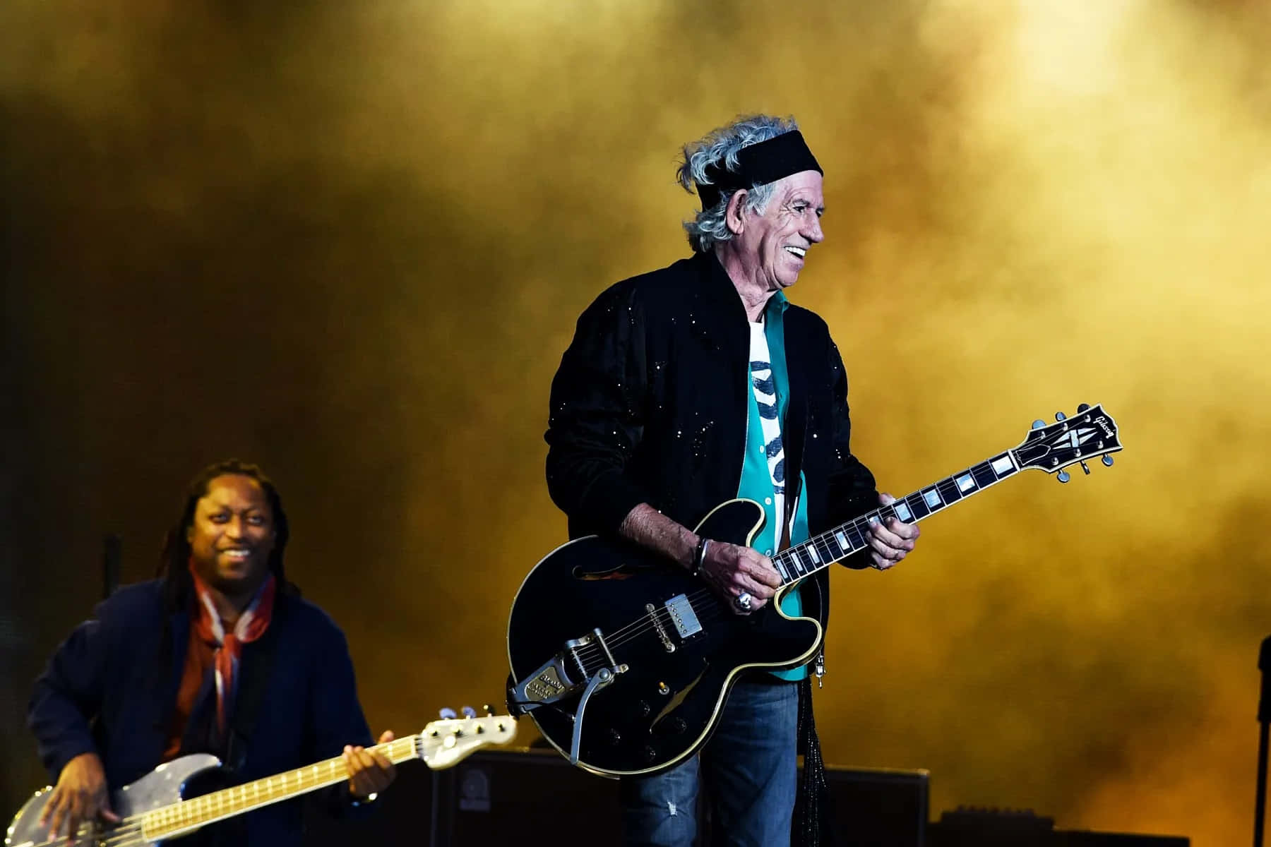 Legendarische Gitarist Op Het Podium Met Bassist Achtergrond