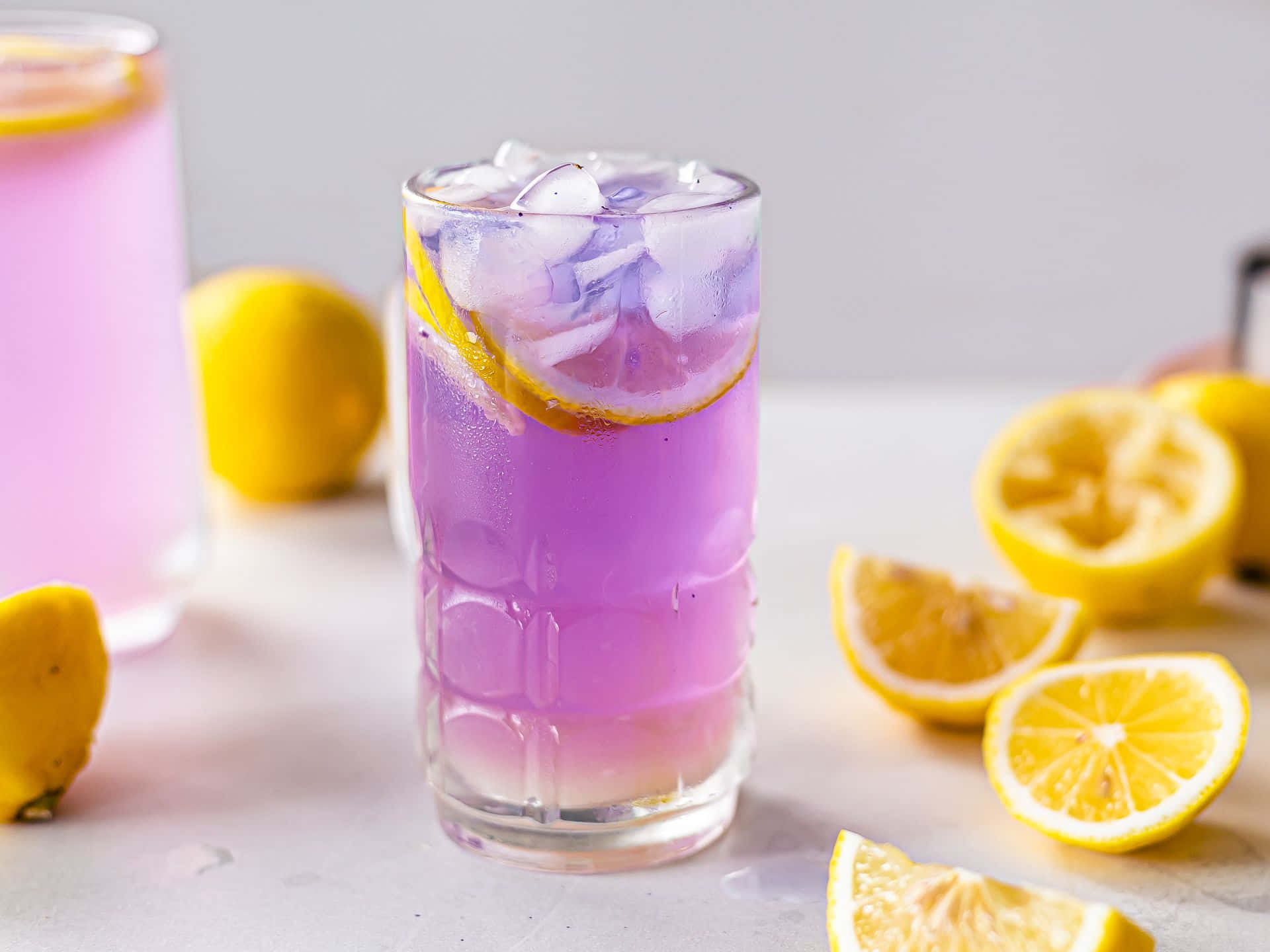 A Purple Drink With Lemon Slices And Ice