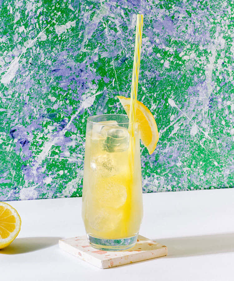 A Glass Of Lemonade With A Straw On A Marble Table