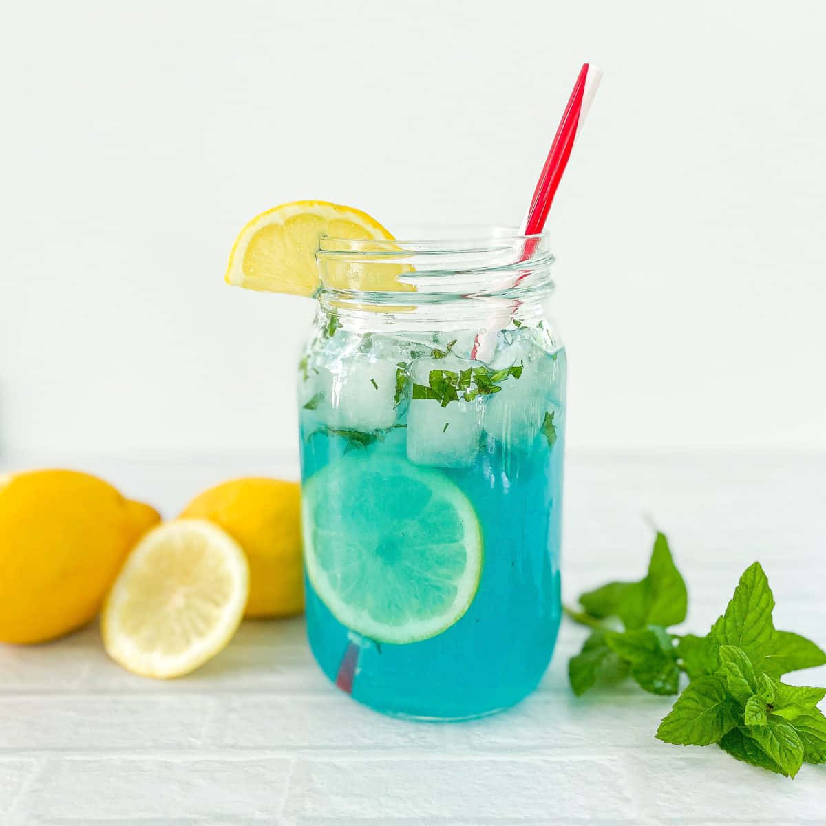 A Blue Drink With Lemon And Mint Leaves