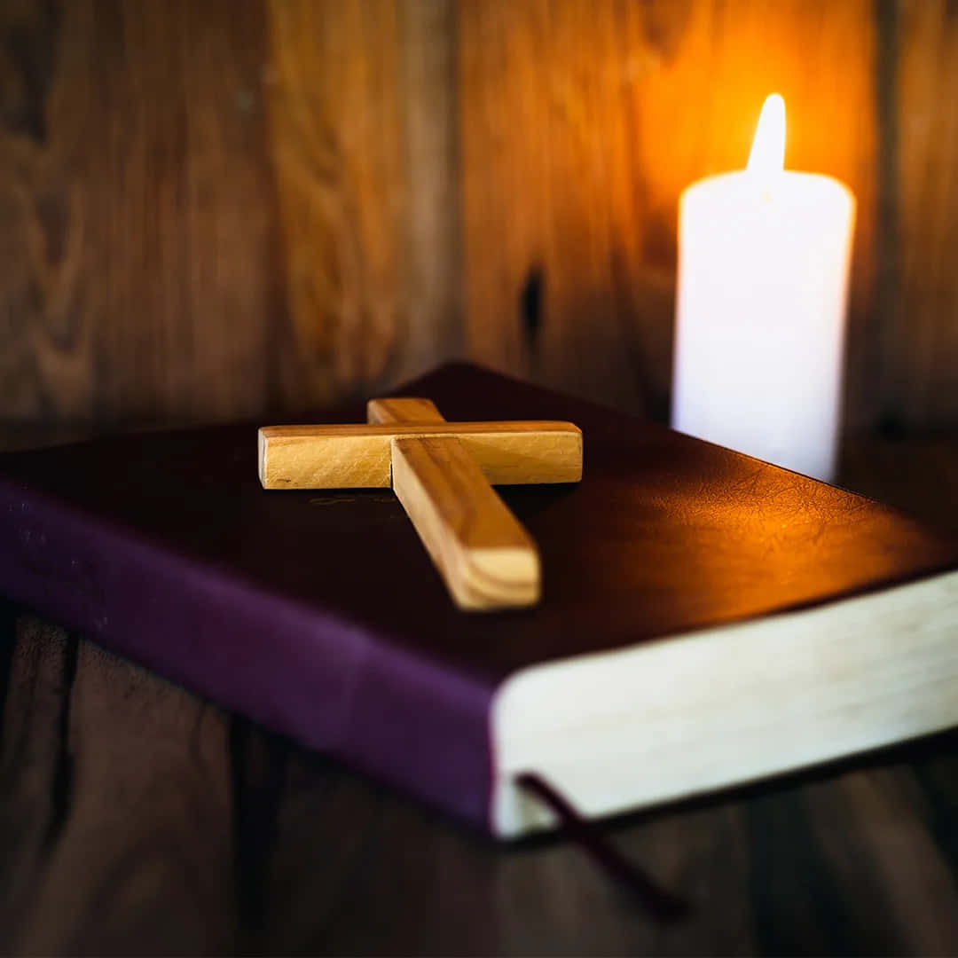 A Bible With A Candle And A Wooden Cross