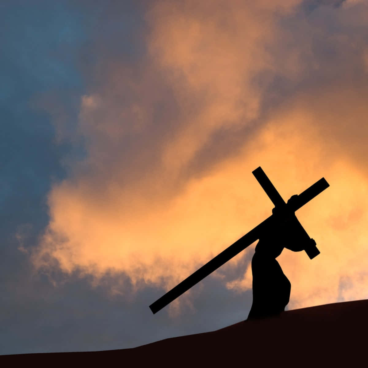 A Silhouette Of A Man Carrying A Cross