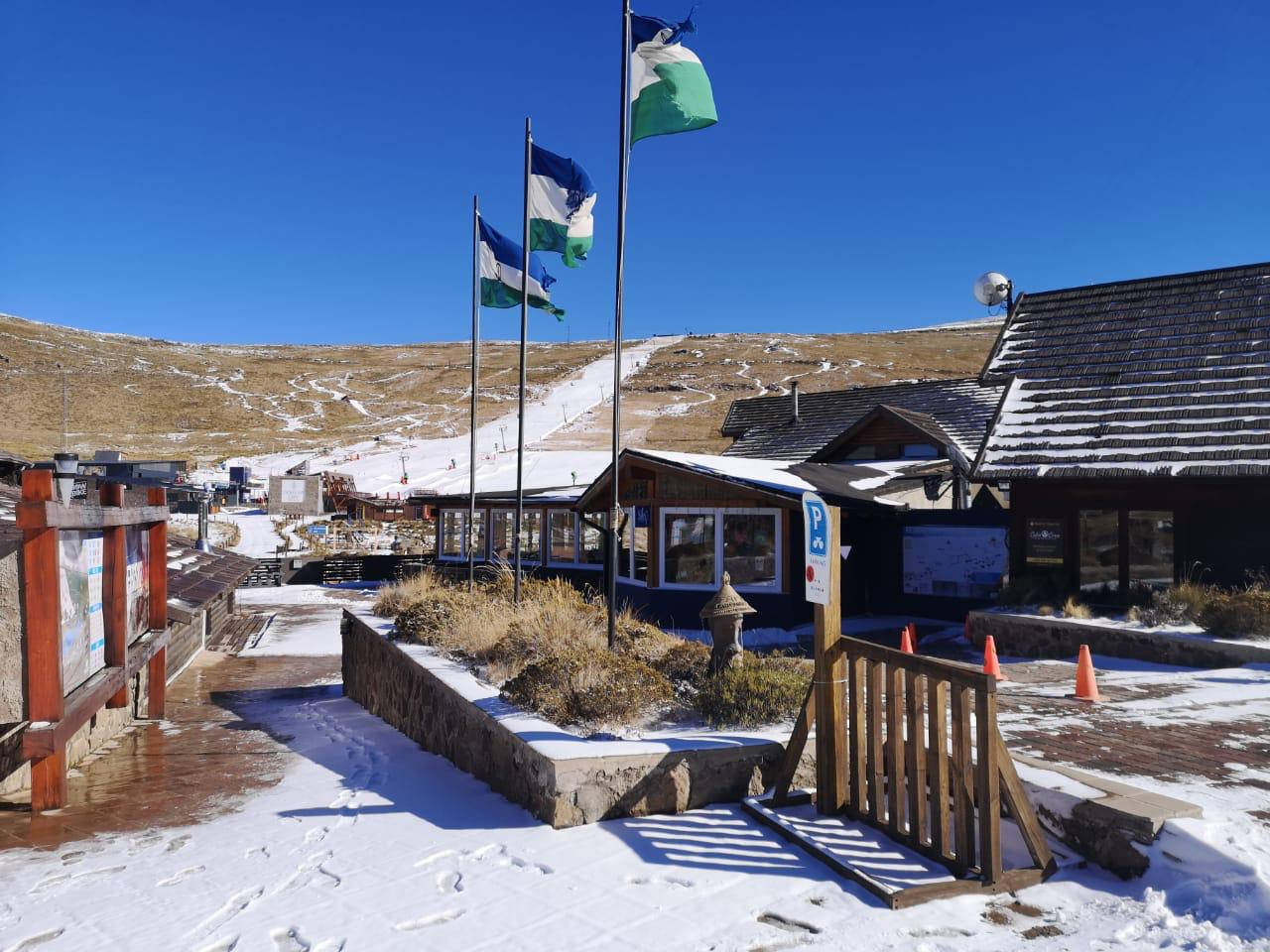 Edificiinnevati Del Lesotho Bandiera Sventolante. Sfondo