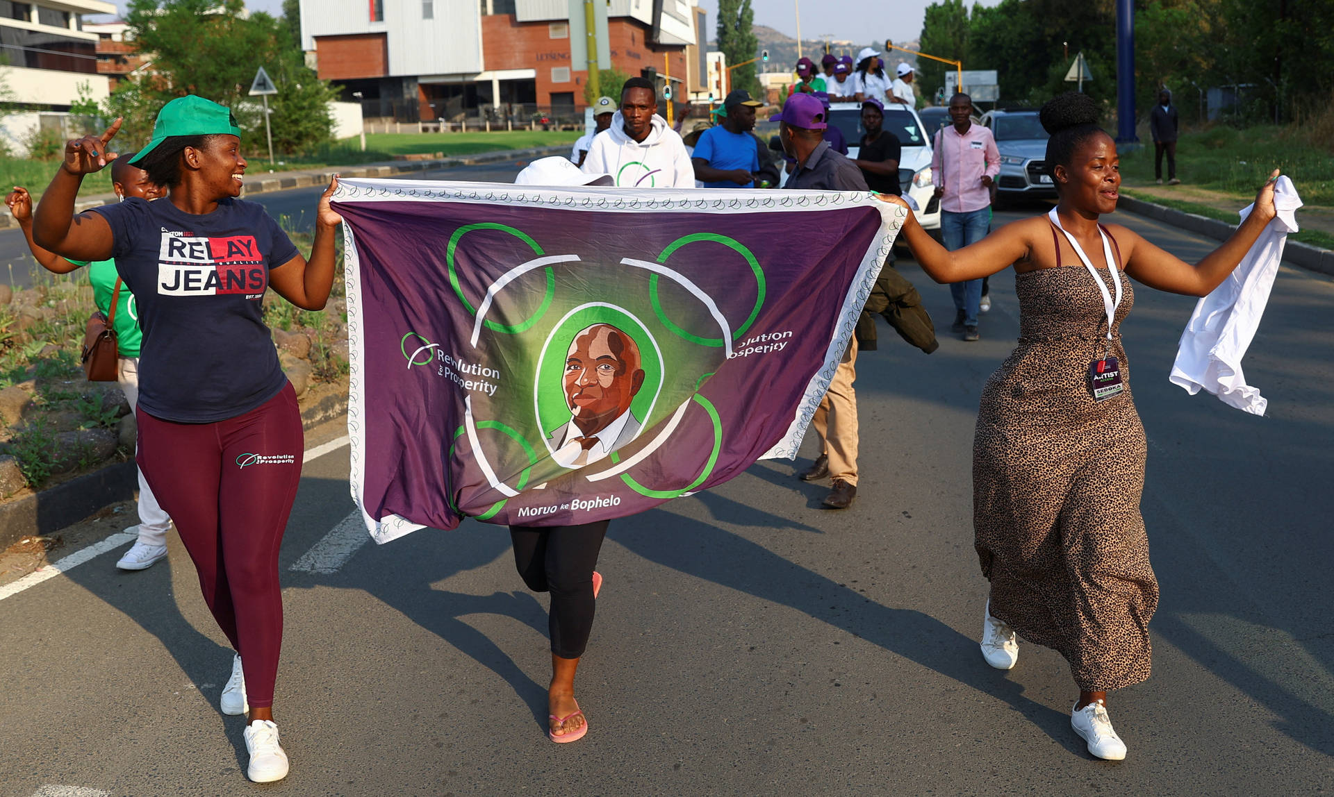 Titolovibrante Cultura Del Lesotho - Donne In Abiti Tradizionali Con Banner Del Re Letsie Iii Sfondo