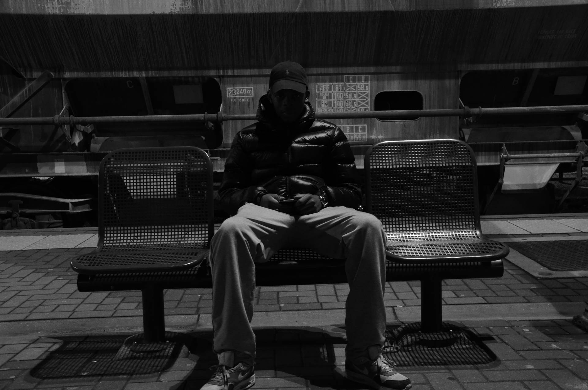 Caption: "Exhausted man resting on a bus bench." Wallpaper