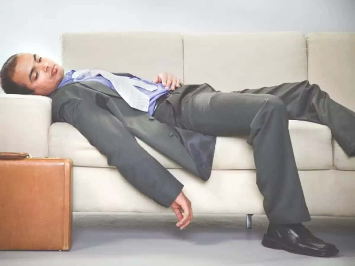 Exhausted Office Worker Taking a Break on Sofa Wallpaper