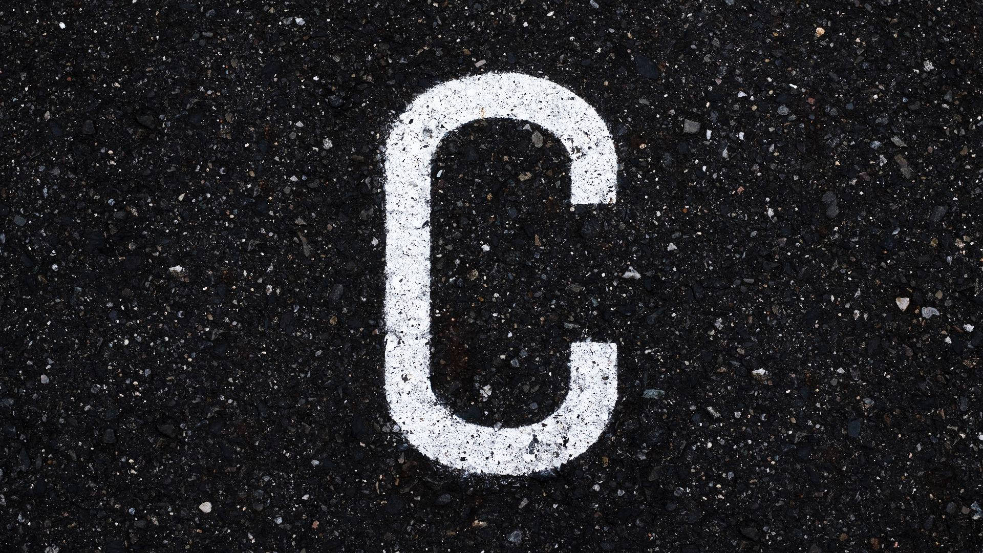 Letter C On Black Asphalt