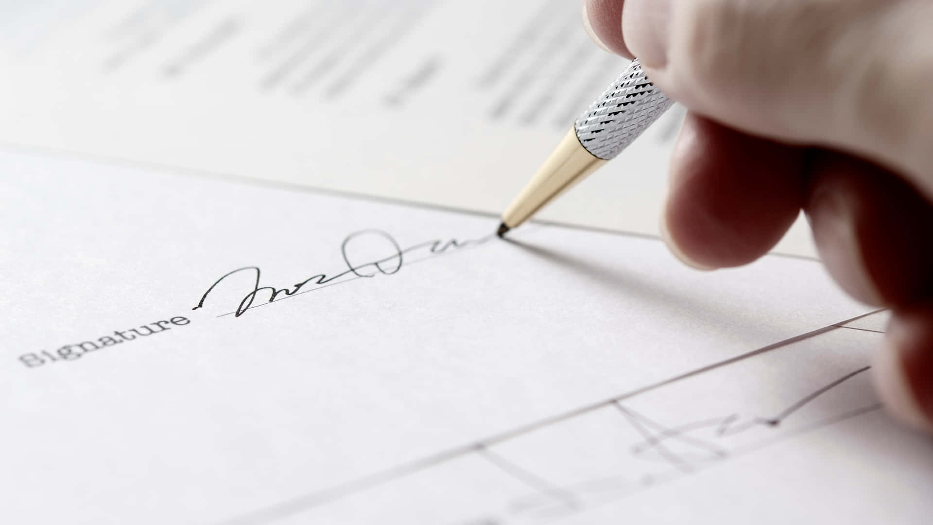 A Person Signing A Document With A Pen