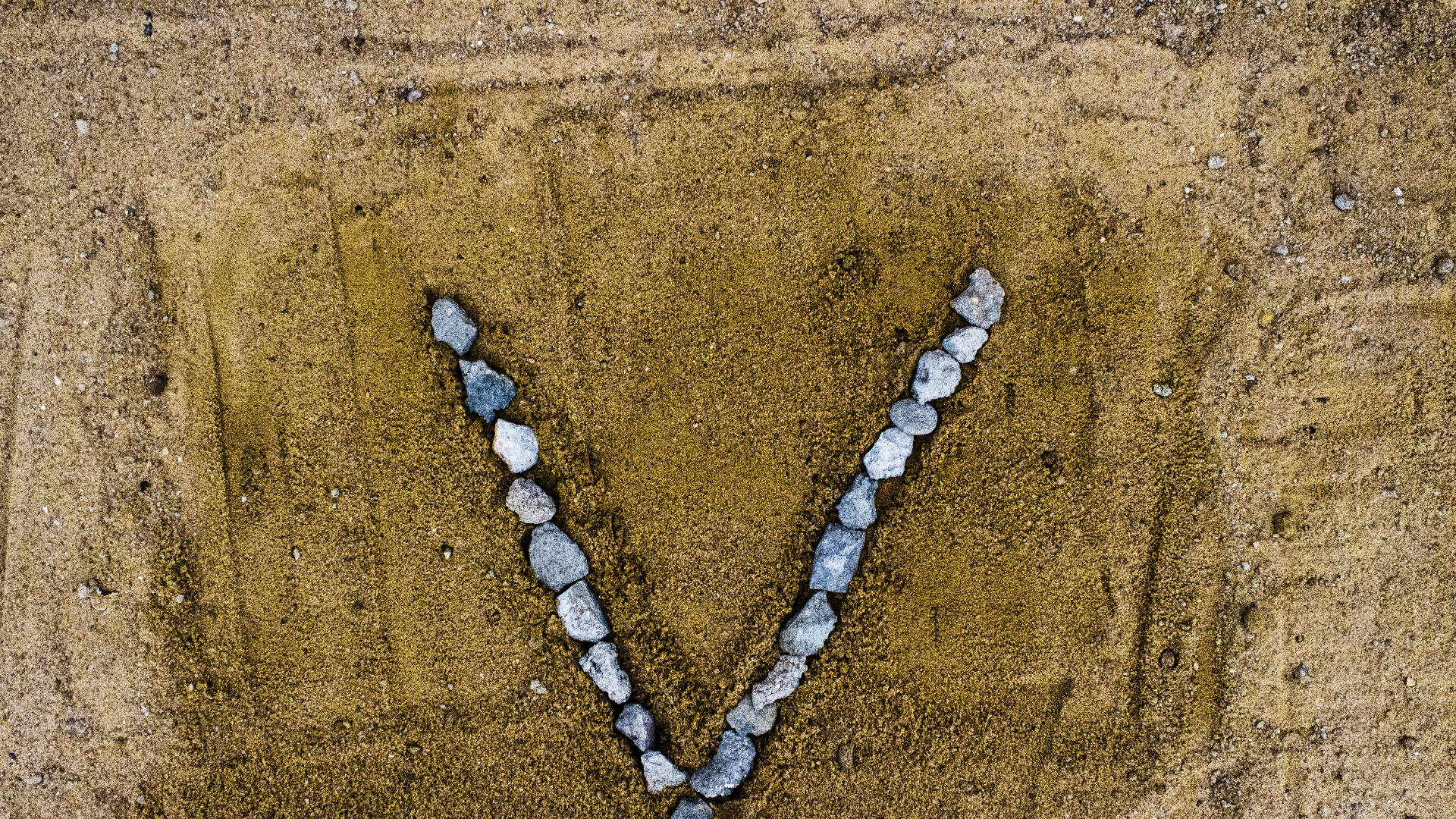 Letter V Shaped Rocks On Sand