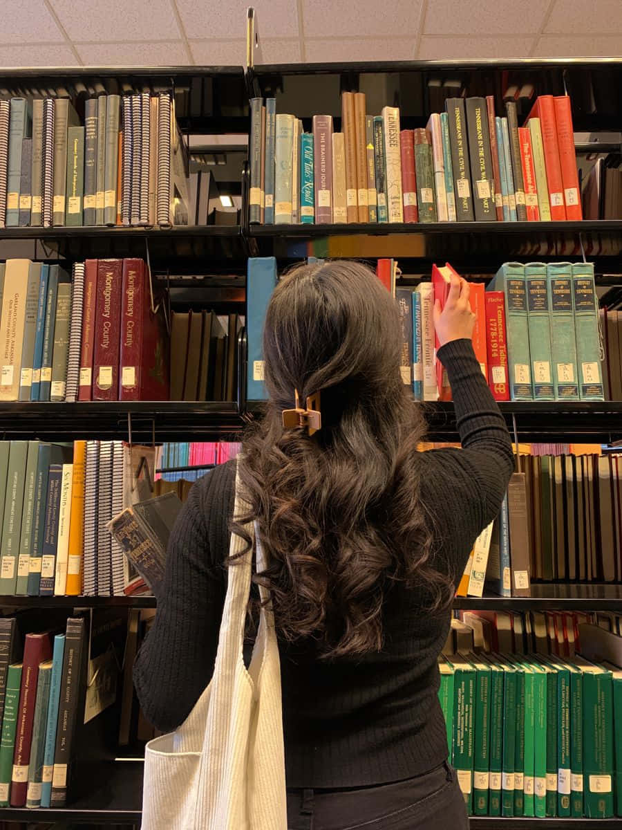 Imagende Una Dama Eligiendo Un Libro En La Biblioteca.