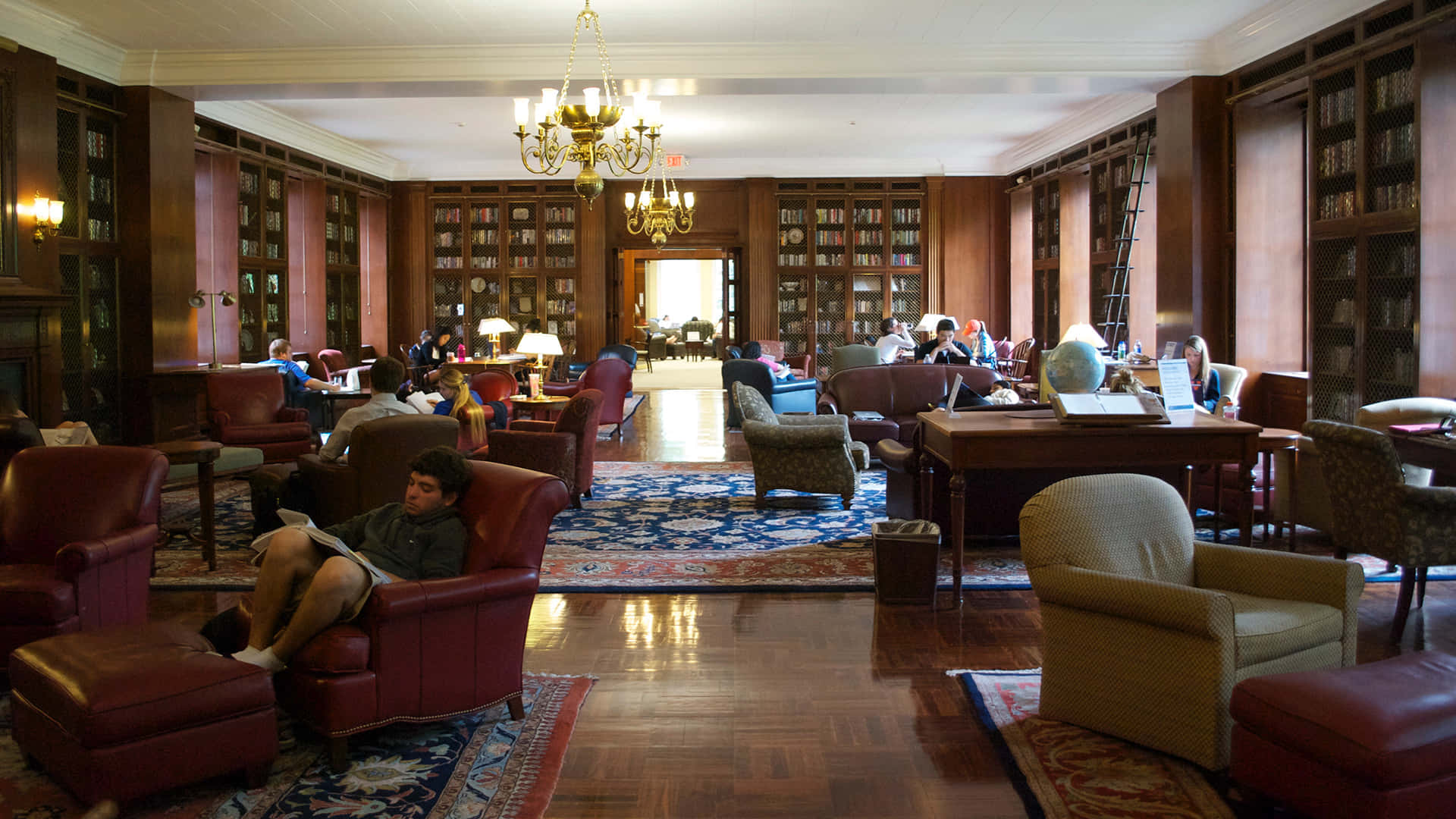 A Large Library With Many People Sitting In Chairs