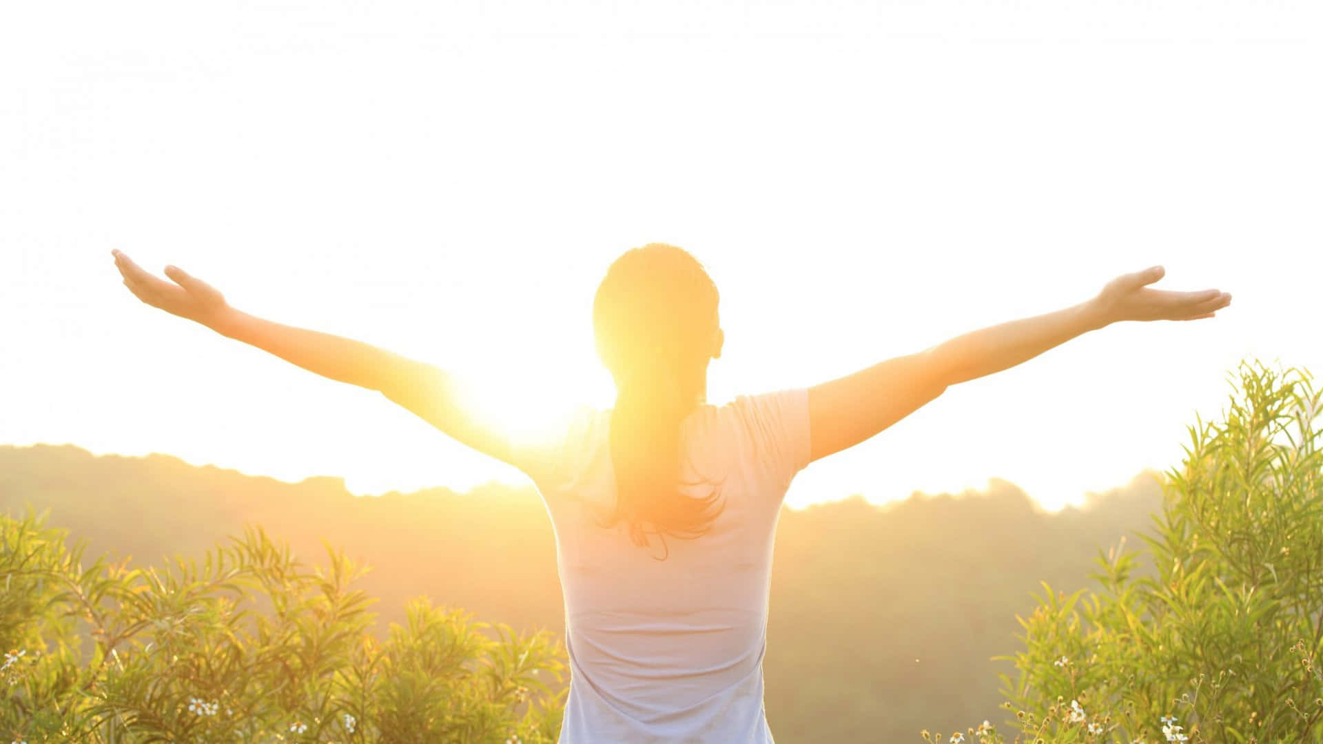 A Woman With Her Arms Outstretched In The Sun