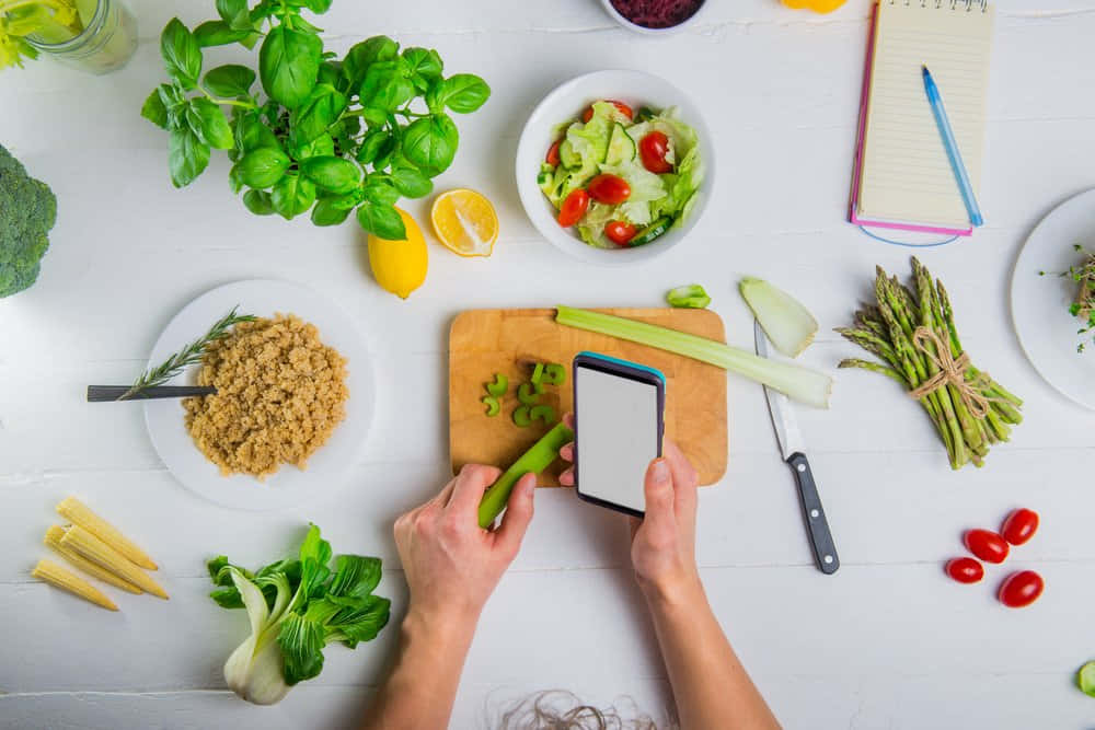 A Woman Is Using Her Phone To Take A Picture Of Vegetables And Fruits