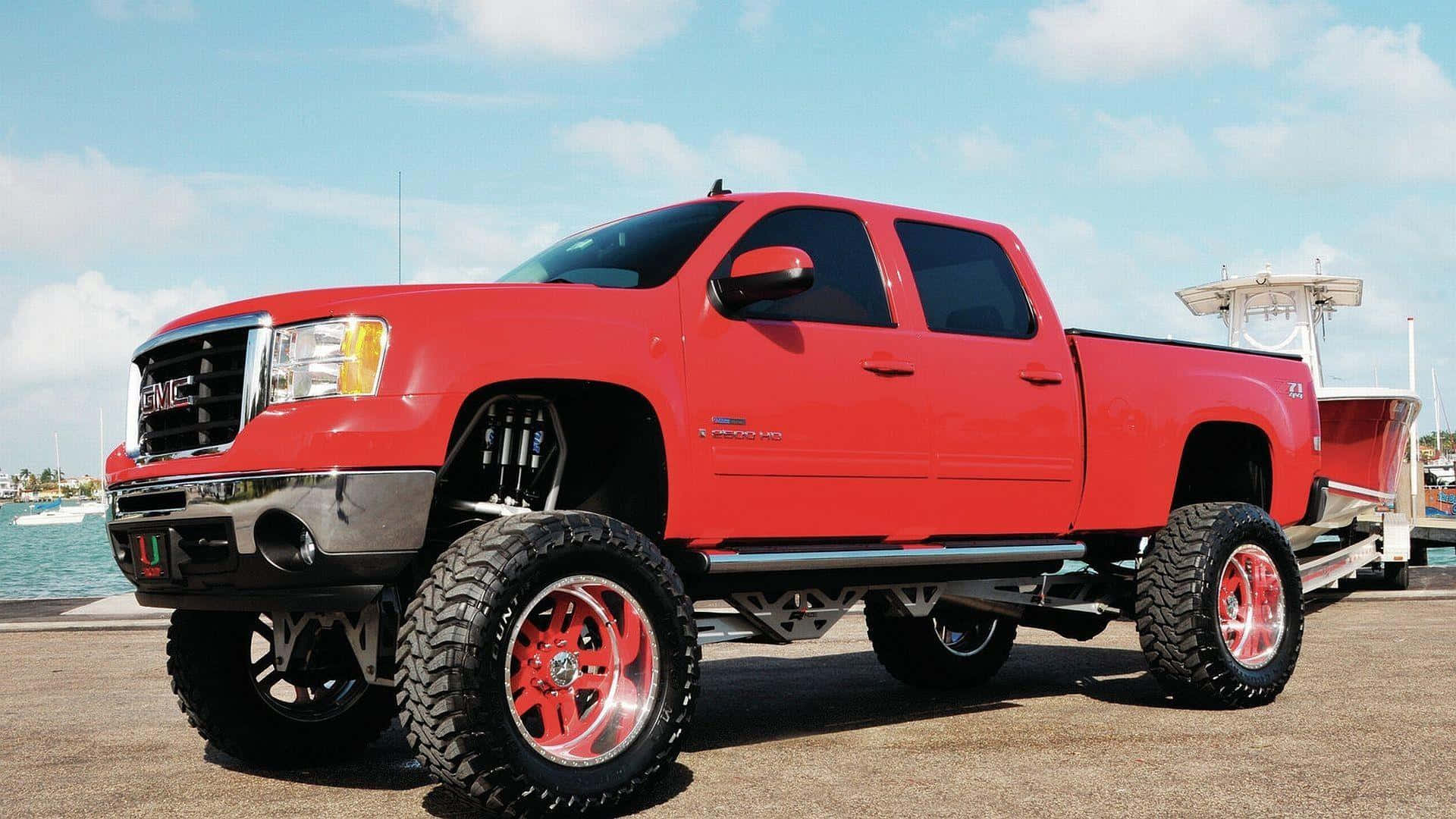 A Red Truck With A Large Set Of Wheels Wallpaper