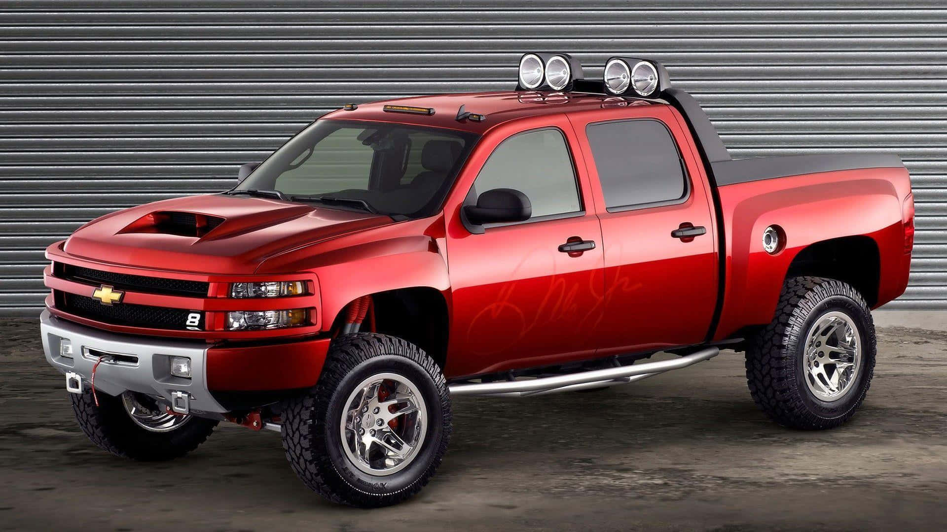 A Red Chevrolet Silverado Truck Is Parked In Front Of A Garage Wallpaper