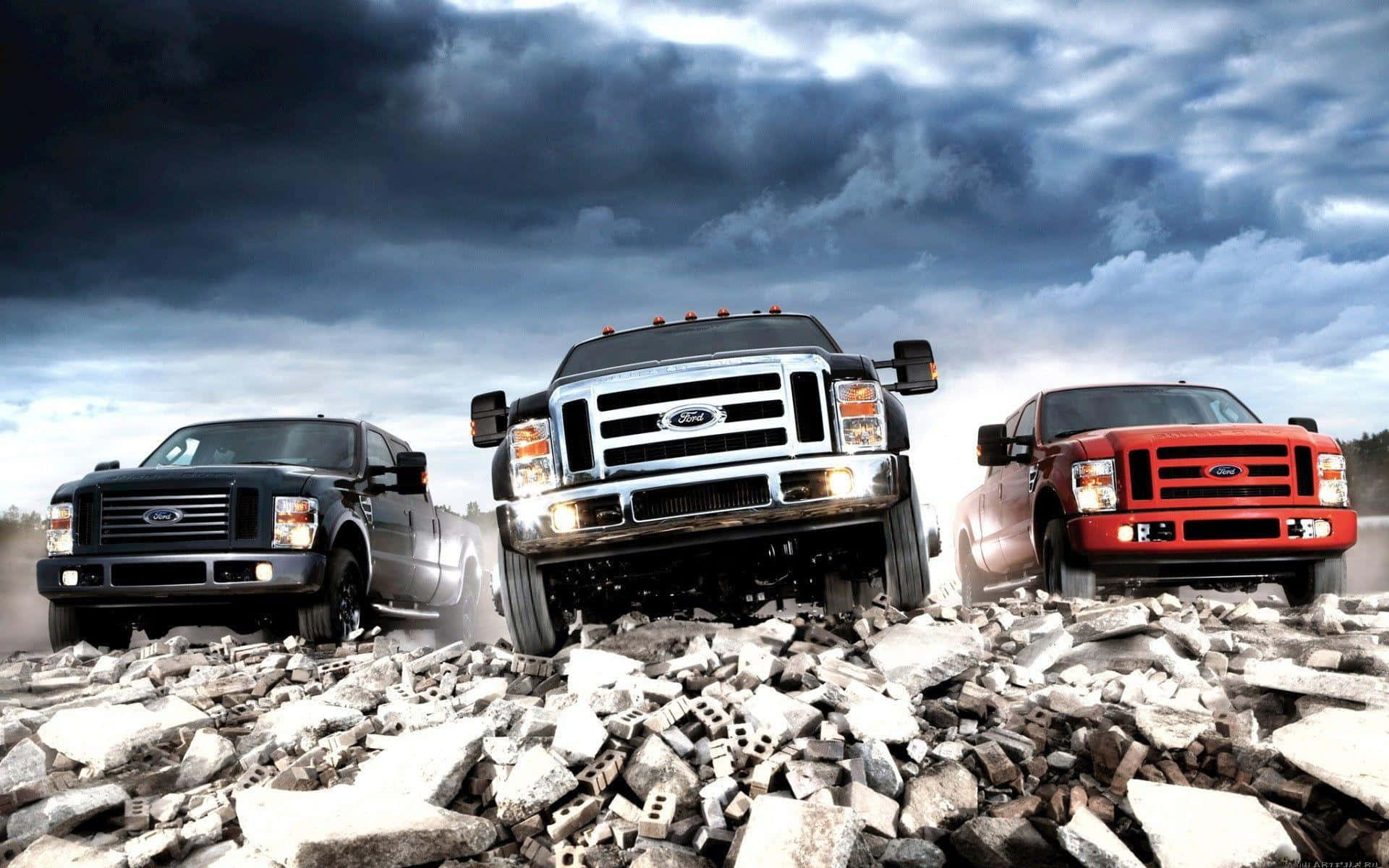 Three Lifted Trucks On Rocky Terrain Wallpaper