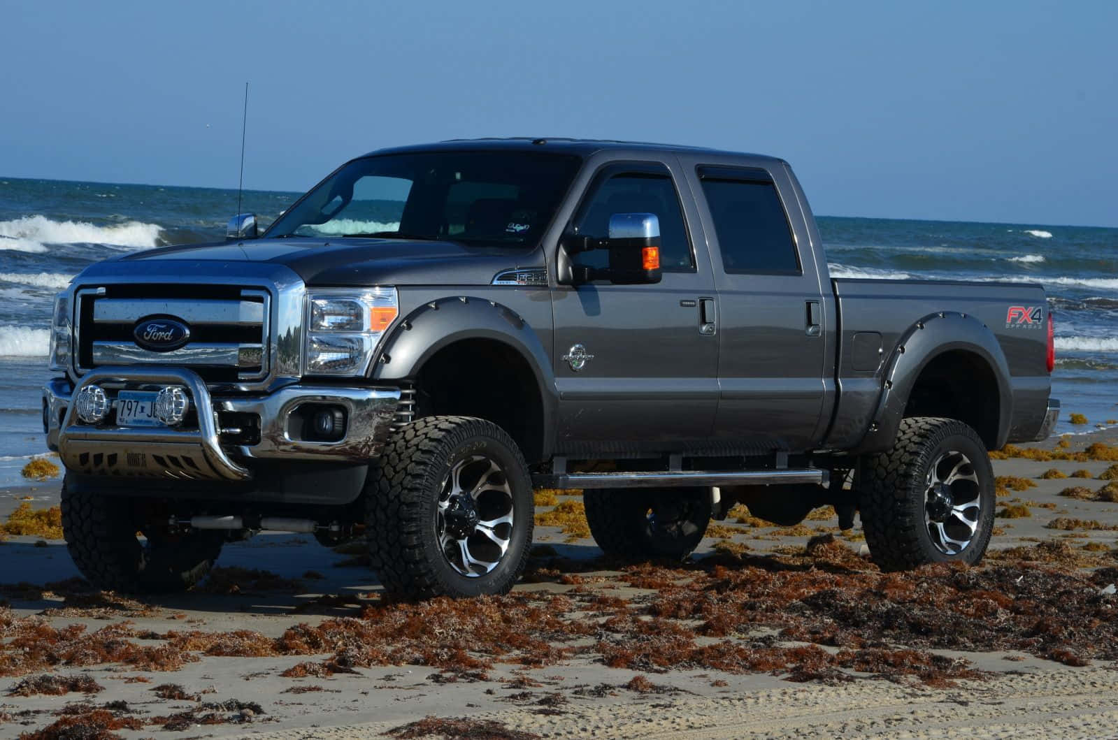 A Gray Truck Is Parked On The Beach Wallpaper